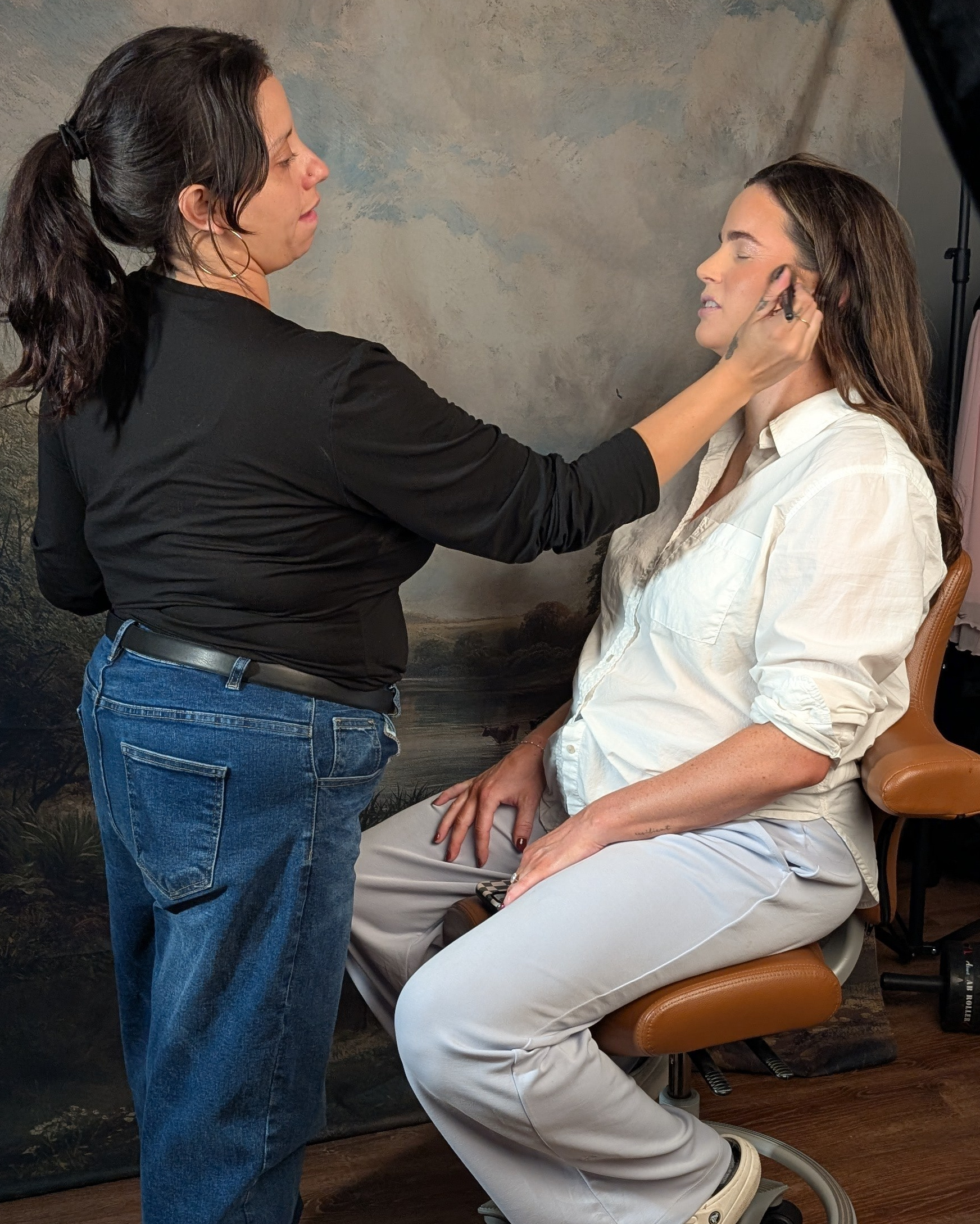 Behind the scenes: the photographer adjusting a client’s pose in the studio