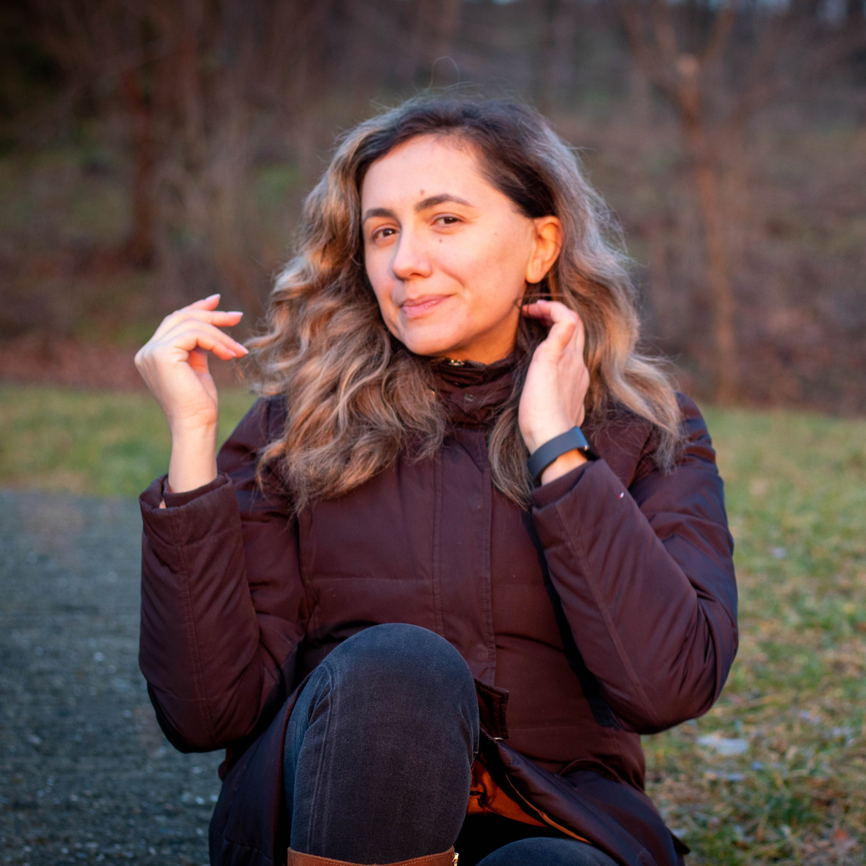 Woman warming her hands on a cold day, natural light autumn portrait
