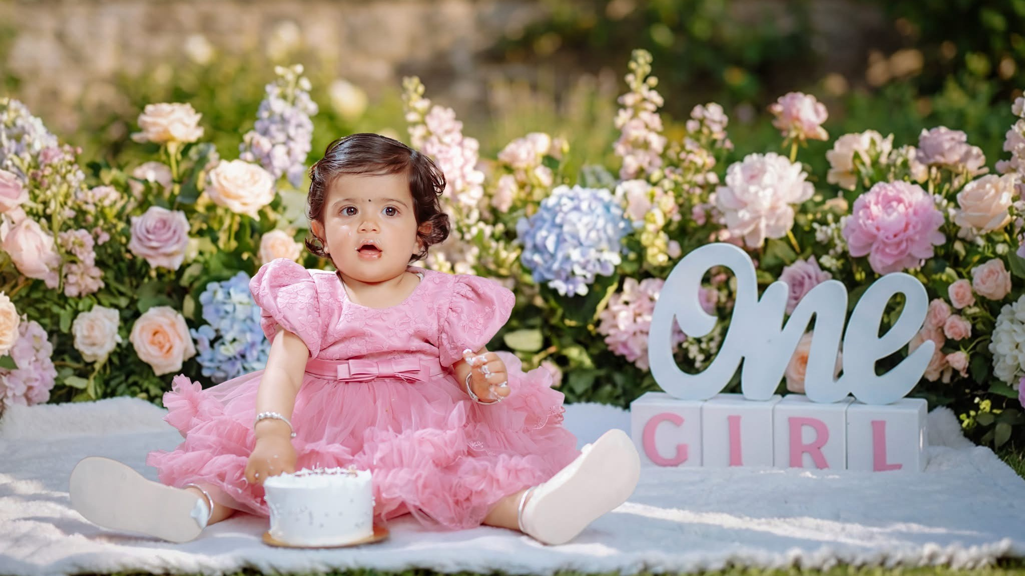 First birthday outdoor portrait of a little girl with floral decorations in Butwal baby studio