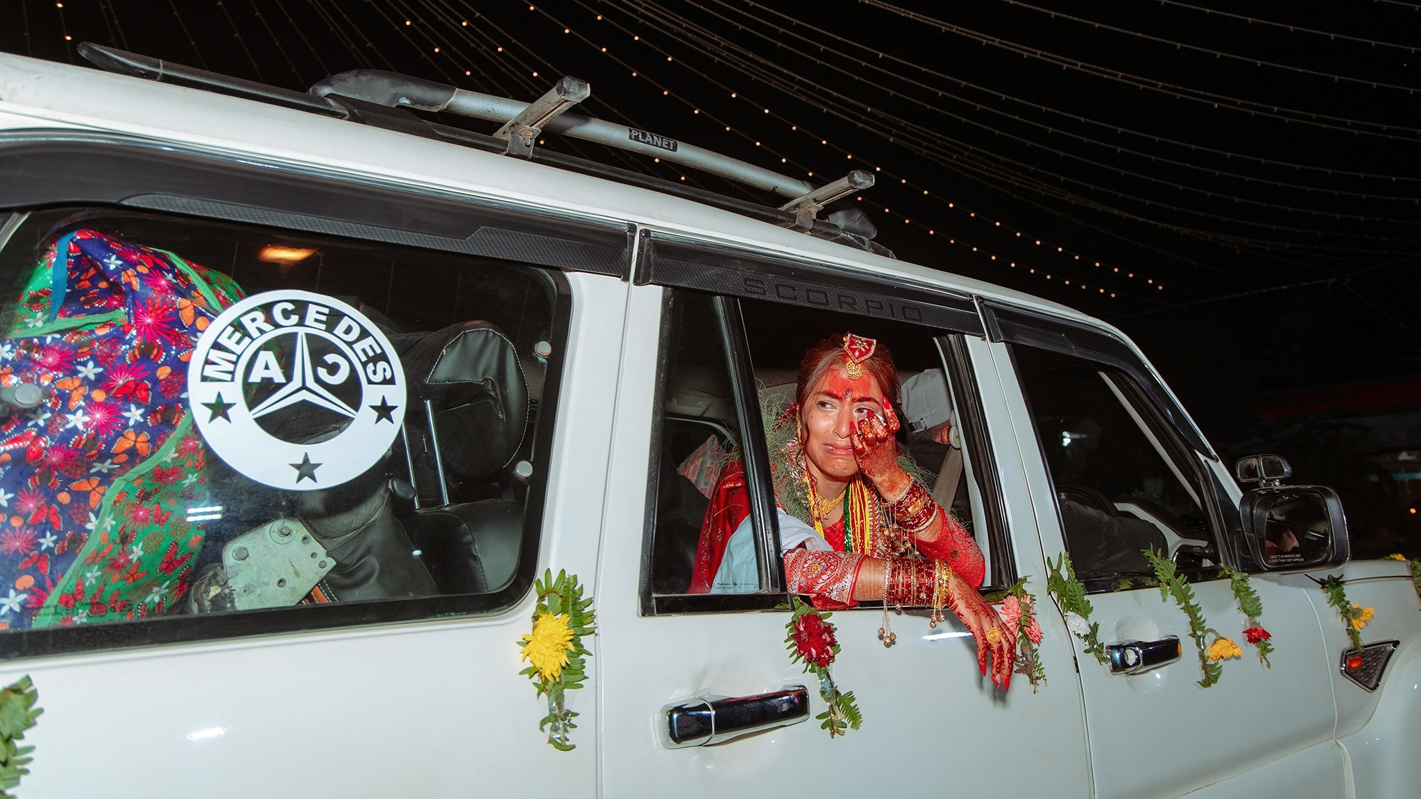 Emotional Nepali bride looking outside the car window during wedding bidai, professional candid shoot at Nepali wedding.