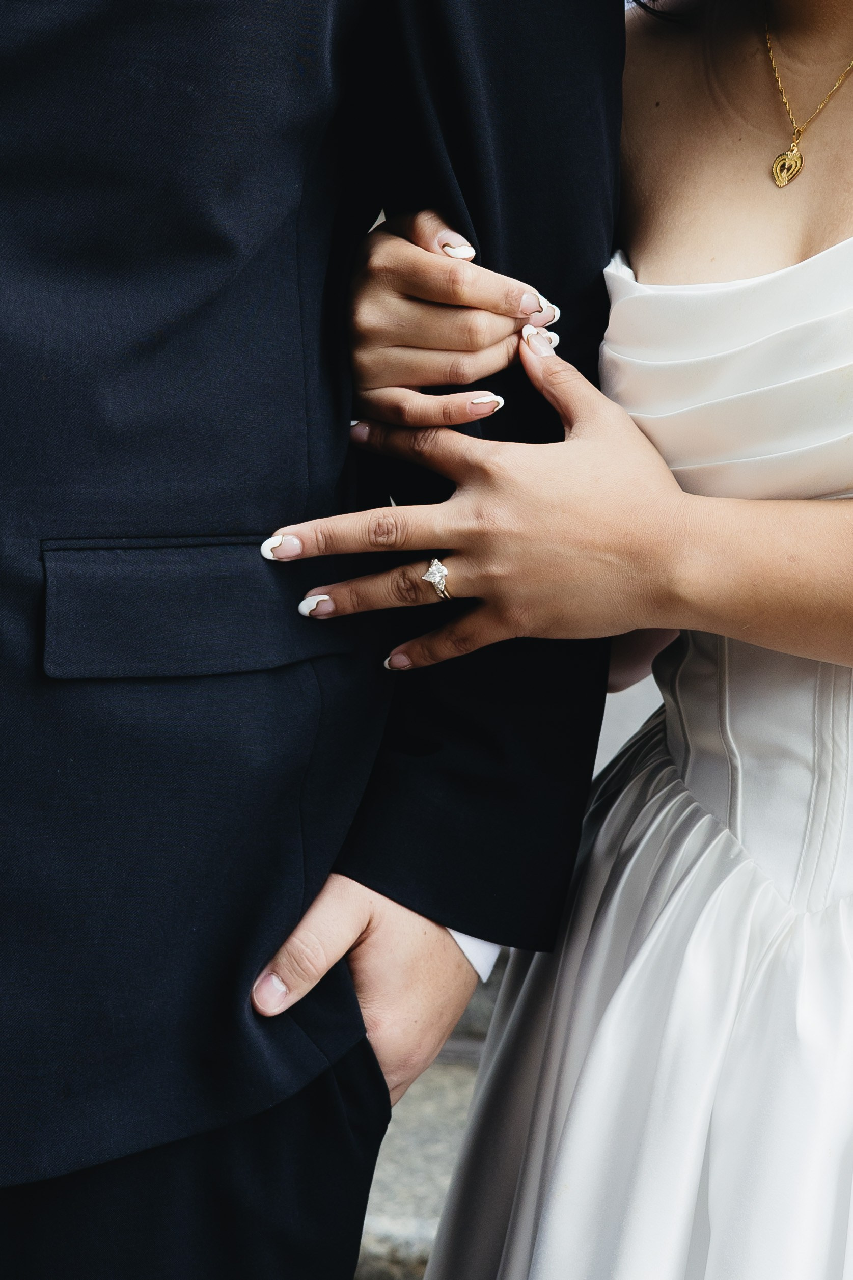 Close-up of bride holding groom’s arm during their elopement
