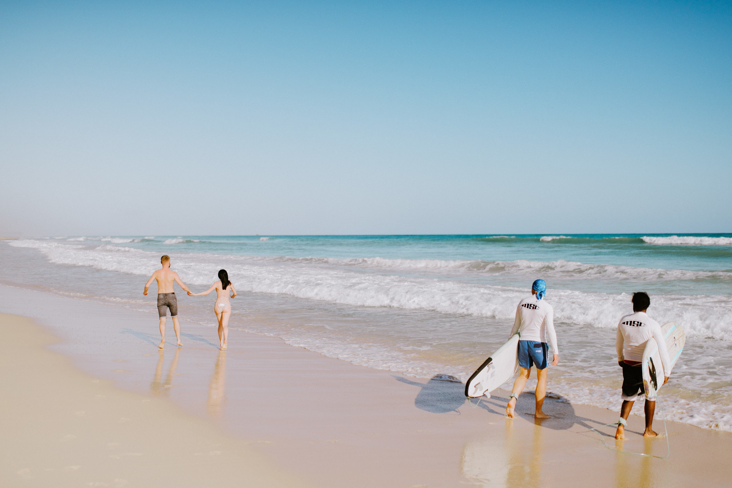 Серфингисты наблюдают за молодоженами. 