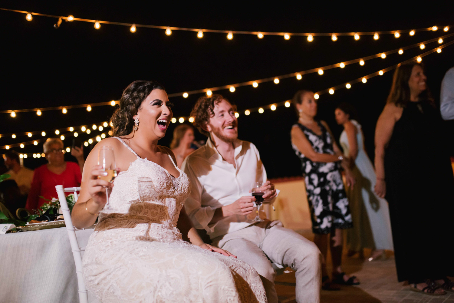 The bride and groom have fun watching the wedding program. 