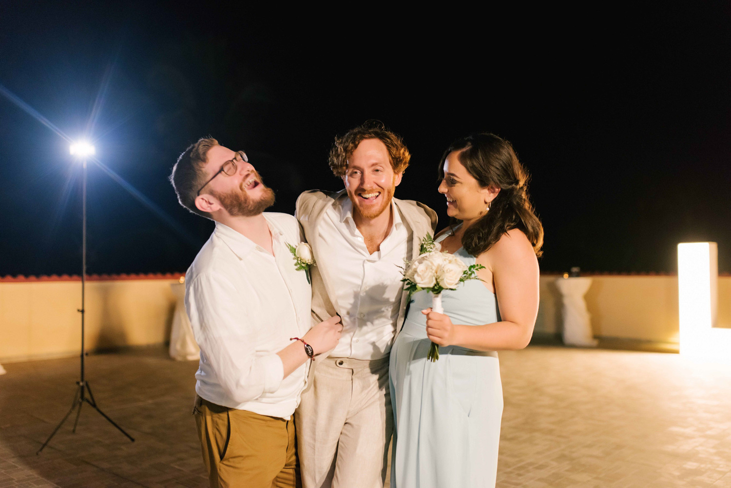 The groom's friends congratulate the groom by hugging him tightly. 
