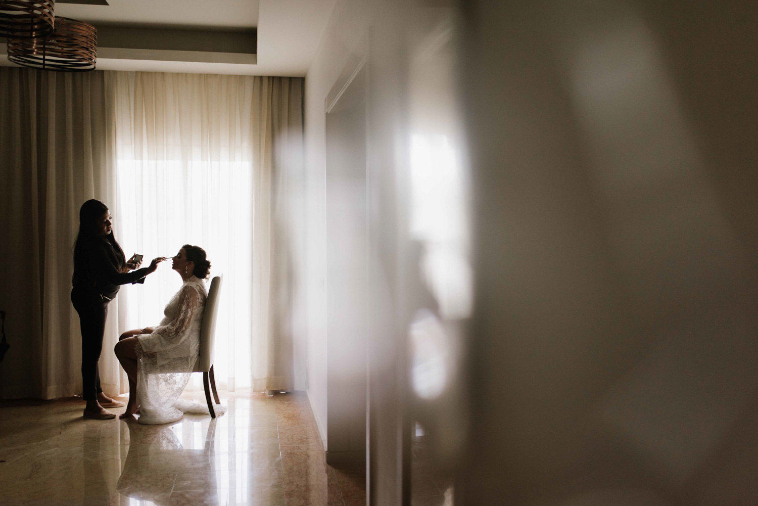 The bride is getting her makeup artist's makeup before the wedding ceremony. 