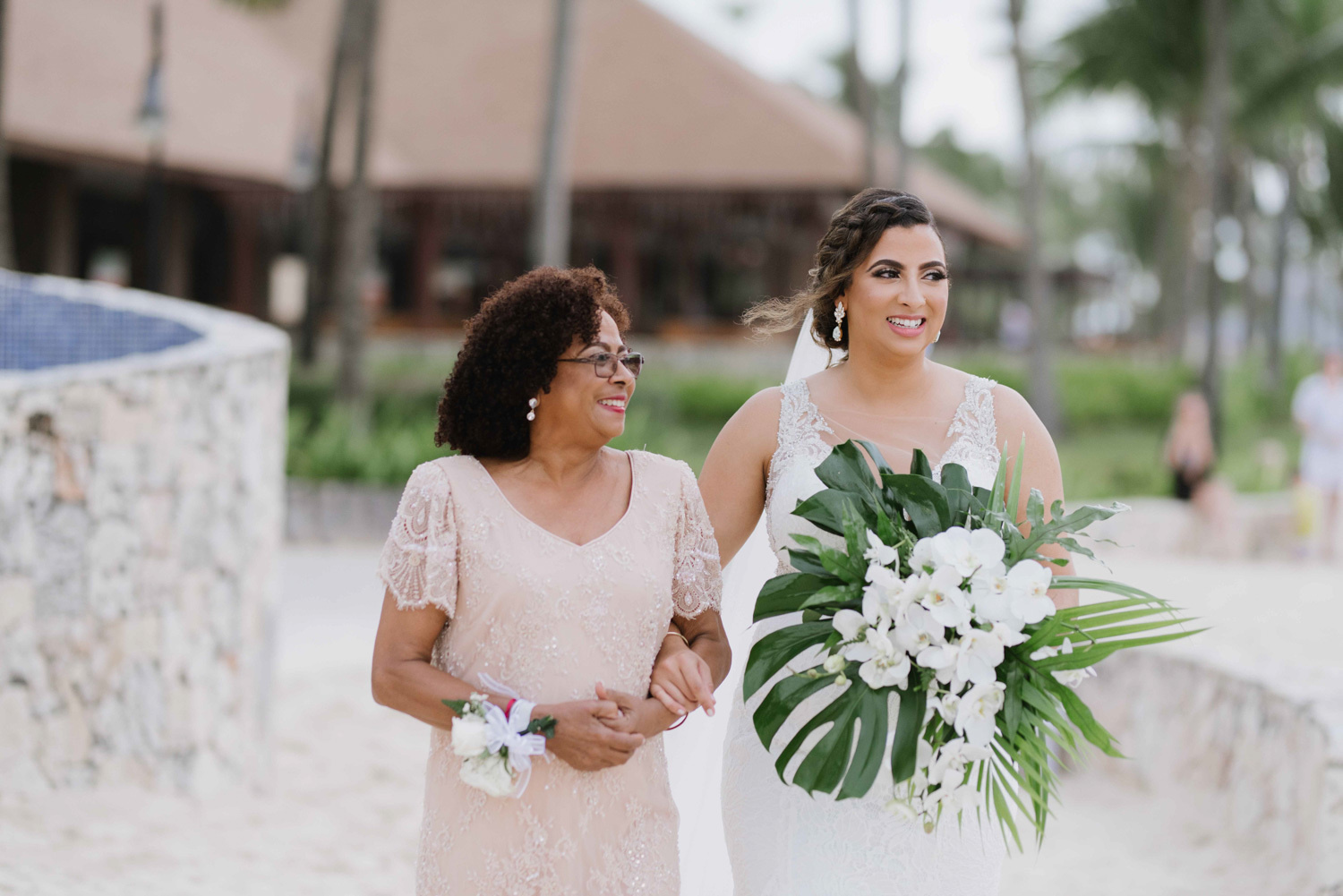 The mother leads the bride down the altar. 