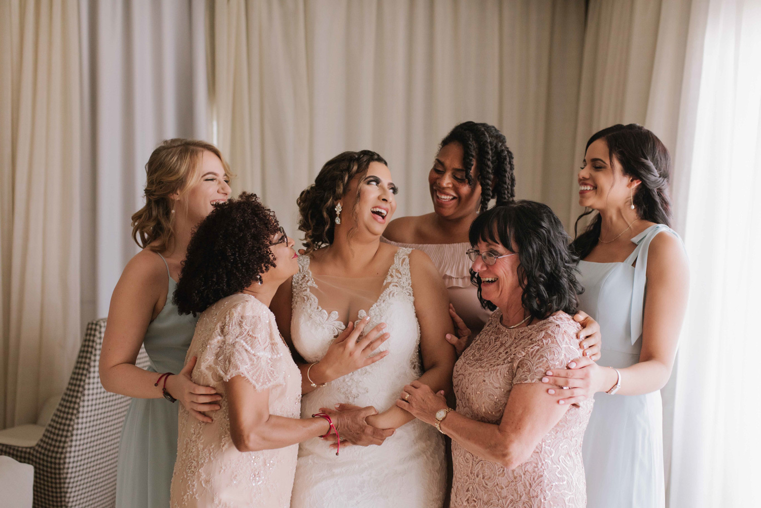Bridesmaids and the bride are posing for a photograph. 