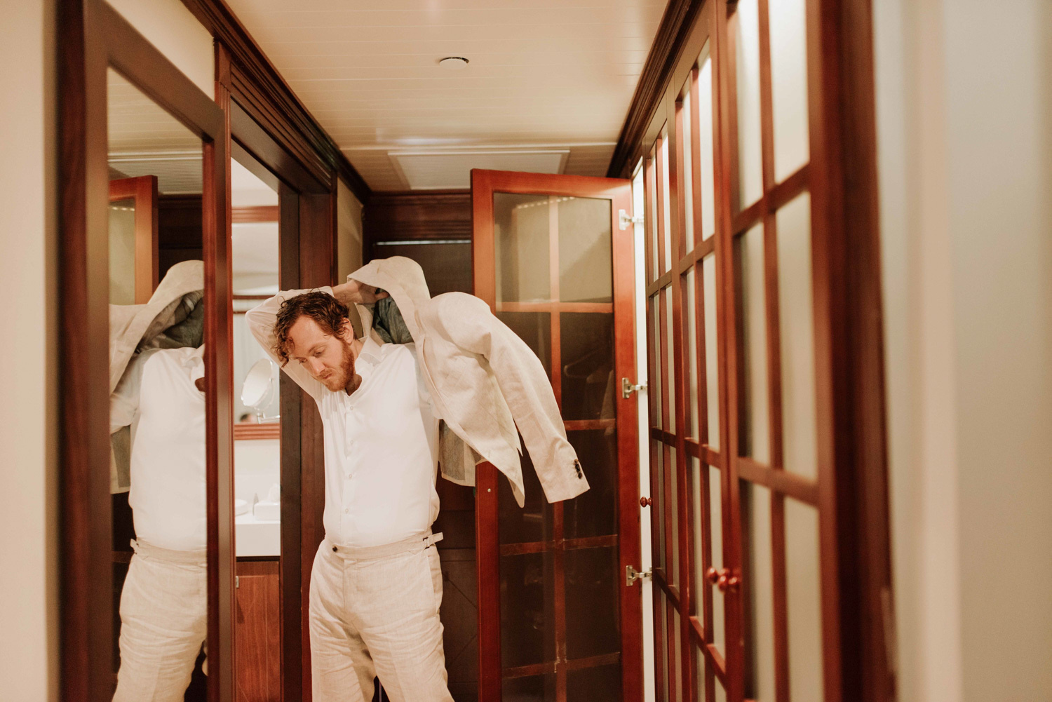 The groom wears a jacket before the wedding ceremony. 