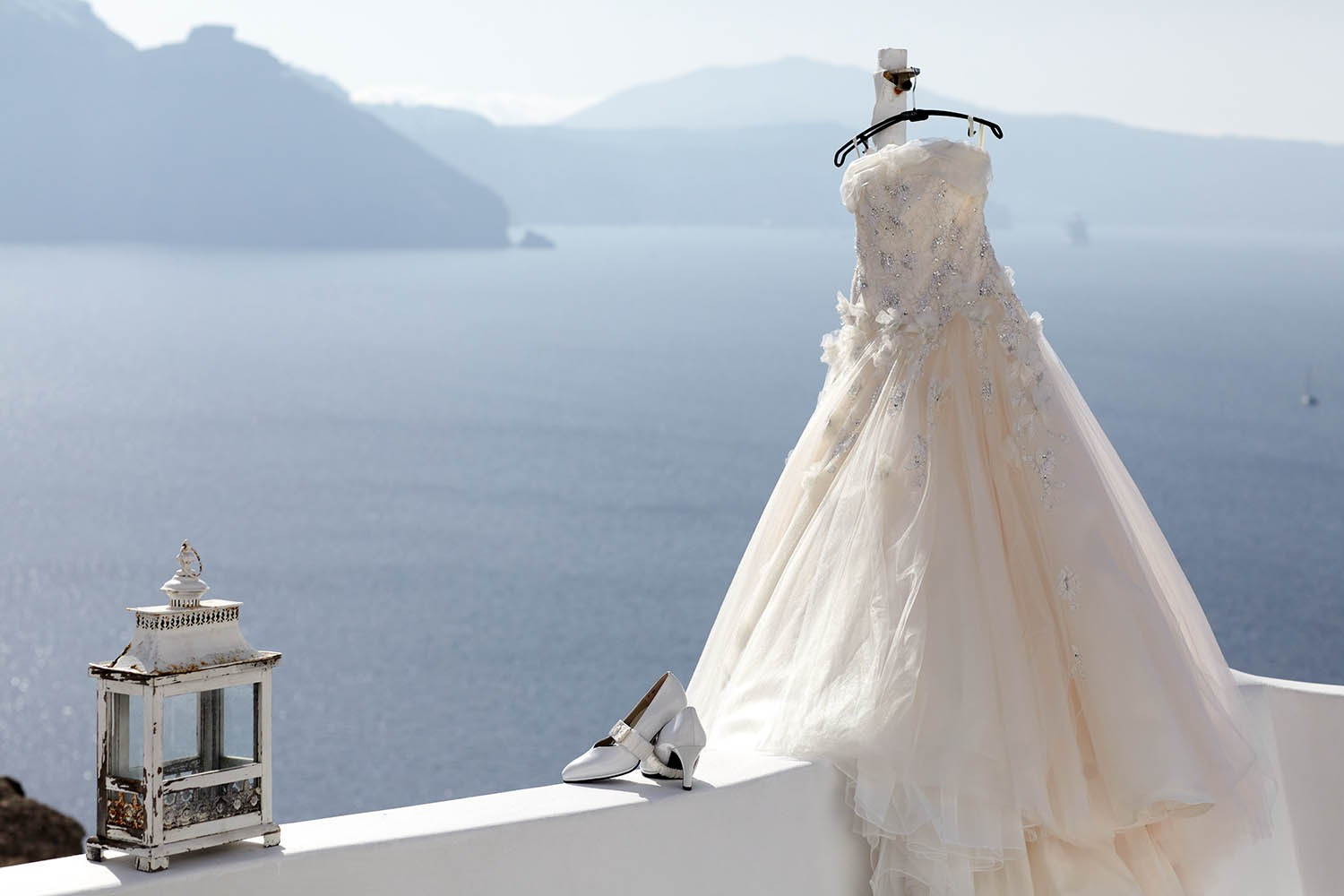 Wedding dress and shoes hanging outside a luxury suite at Adronis Suites in Oia, Santorini.