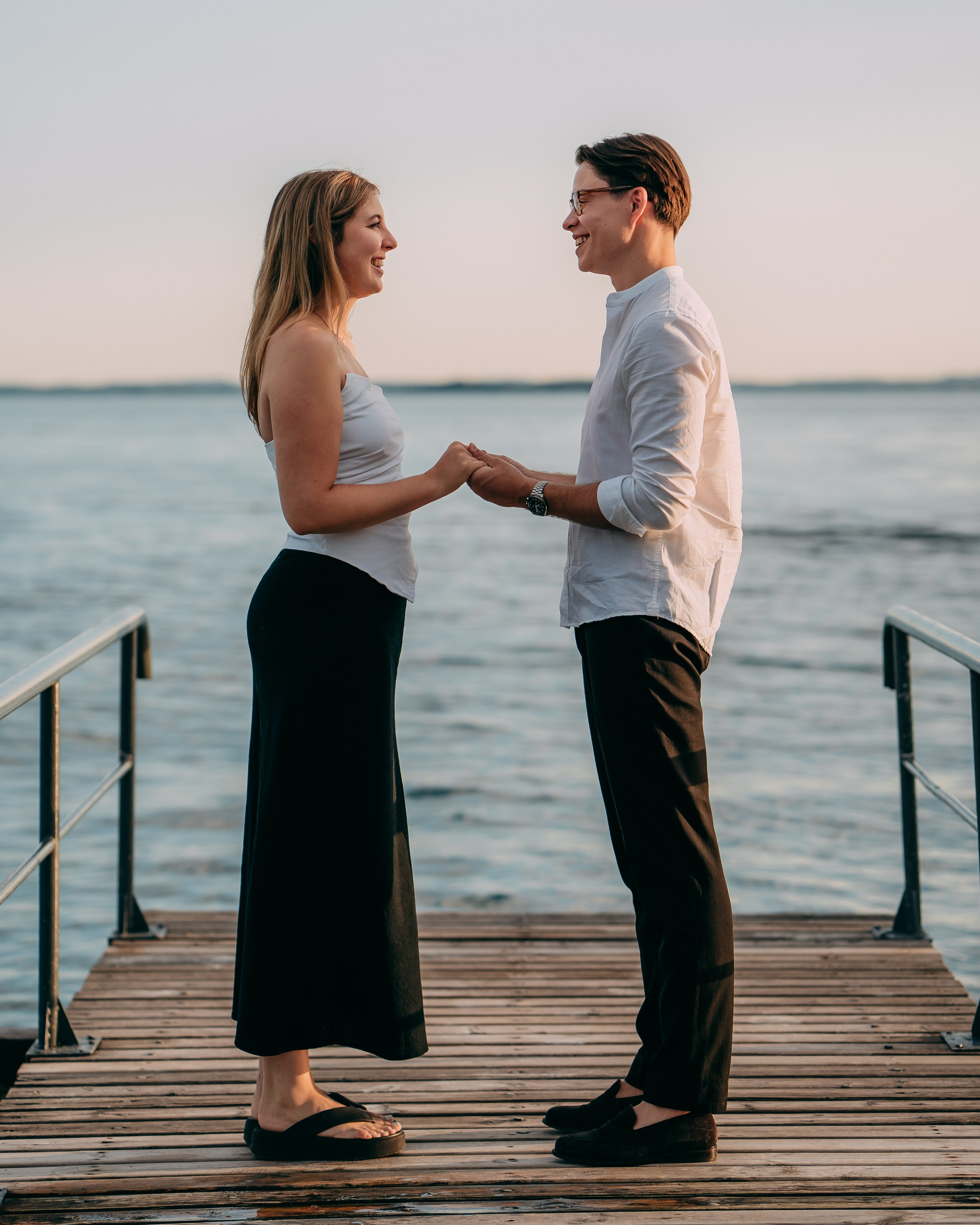 Marriage proposal at Lake Garda on a wooden pier at sunset.