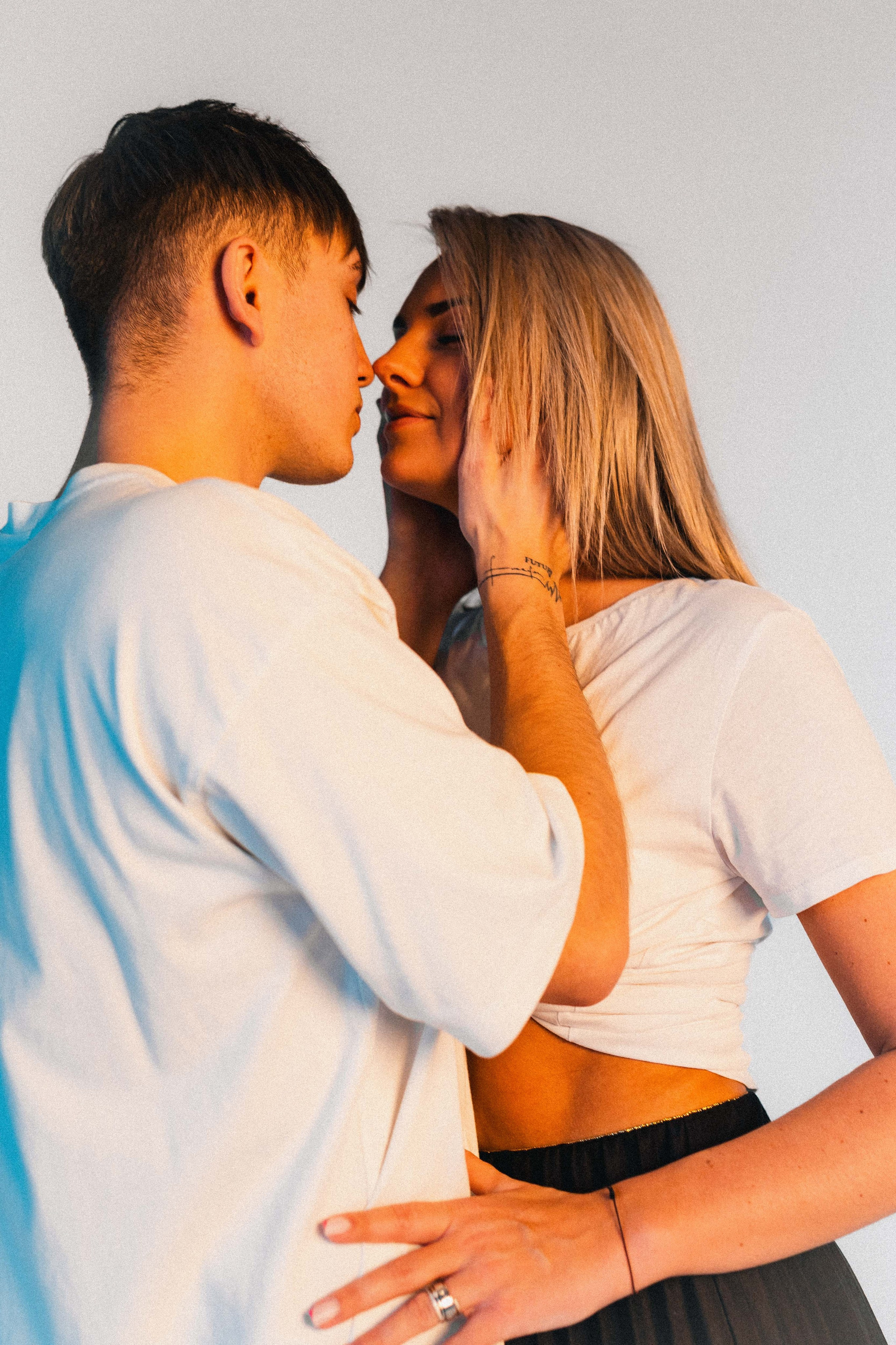 Poros fotosesija Love Story stiliumi – jauna pora apsikabinusi, fotografuota Jevgenijaus Balezino studijoje Vilniuje