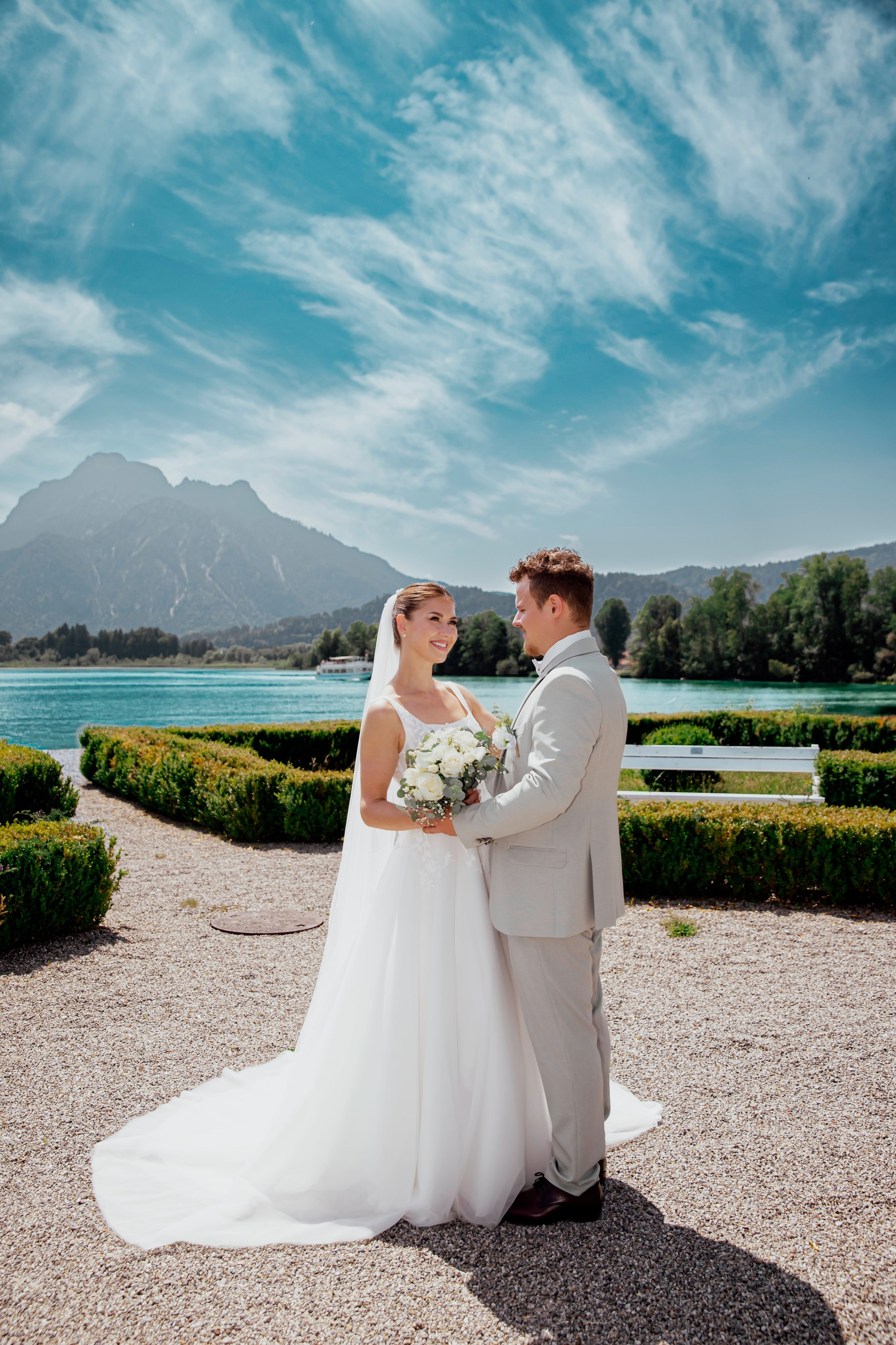 alt="Professioneller Hochzeitsfotograf aus Bayern fotografiert glückliches Brautpaar in ländlicher Umgebung"