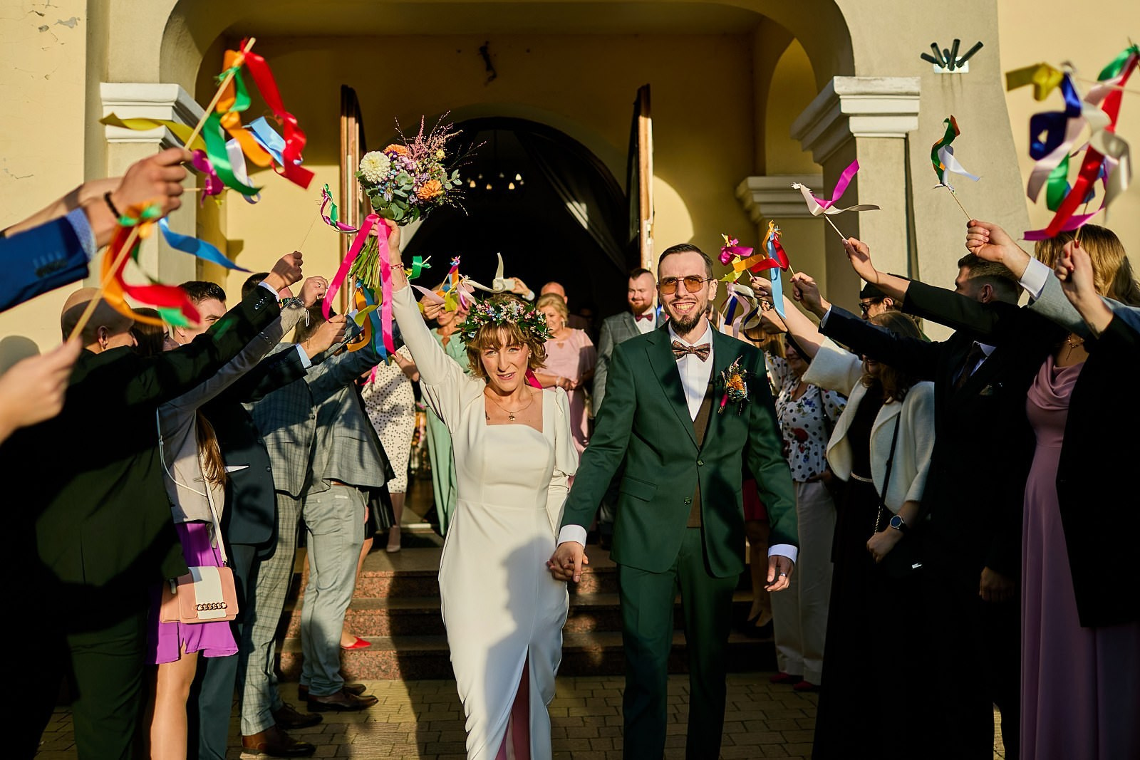 Radosne wyjście pary młodej z kościoła pod deszczem konfetti. Autentyczne emocje w reportażu ślubnym Zapisane Historie.