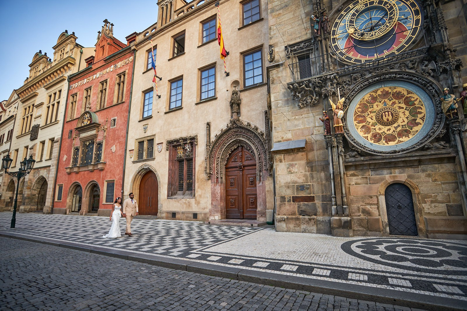 Bride and groom walk underneath the Old Town Hall on their way to the Astronomical Clock