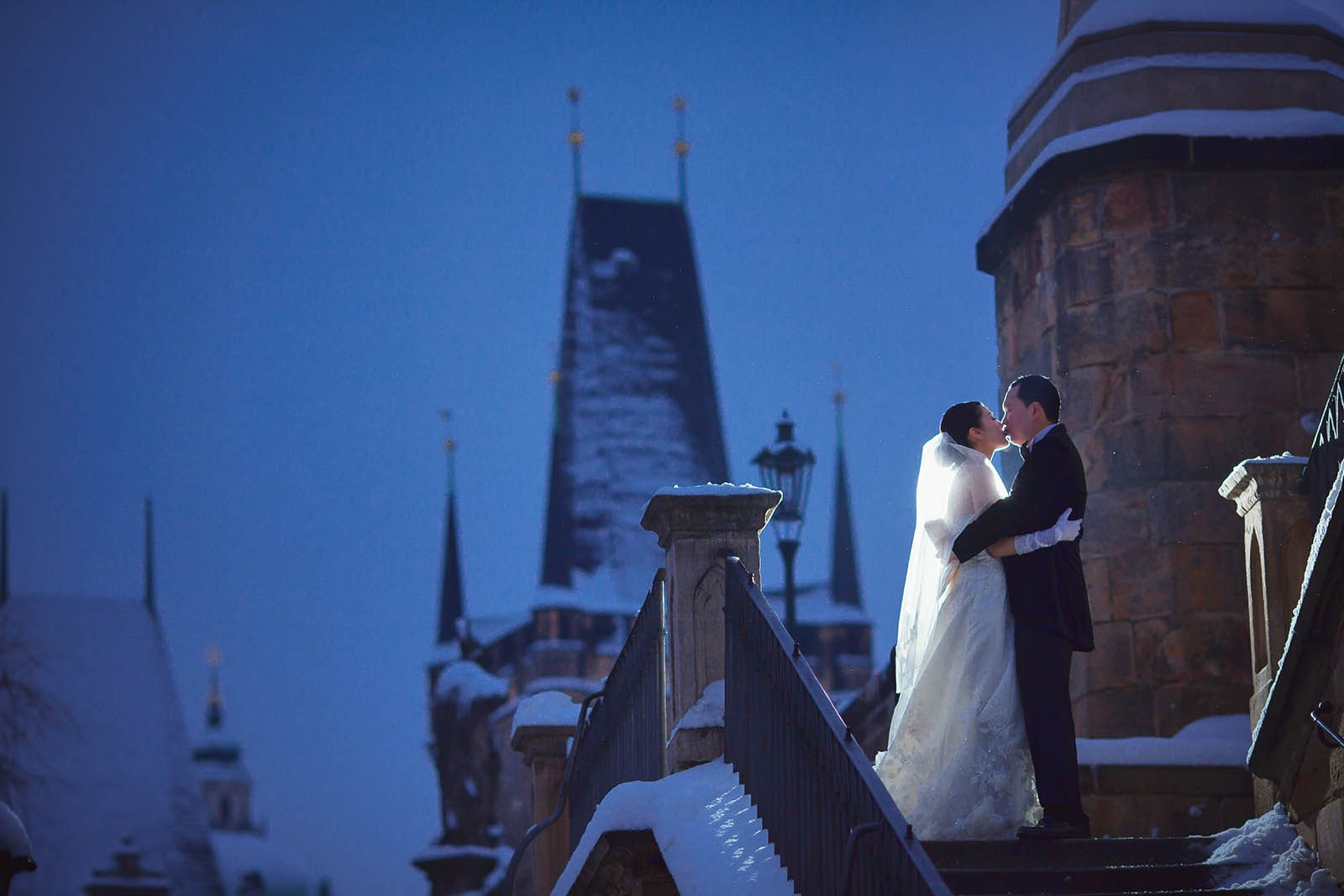 Helen and CY embrace atop the Kampa Steps in Prague, with the Charles Bridge tower in the background.