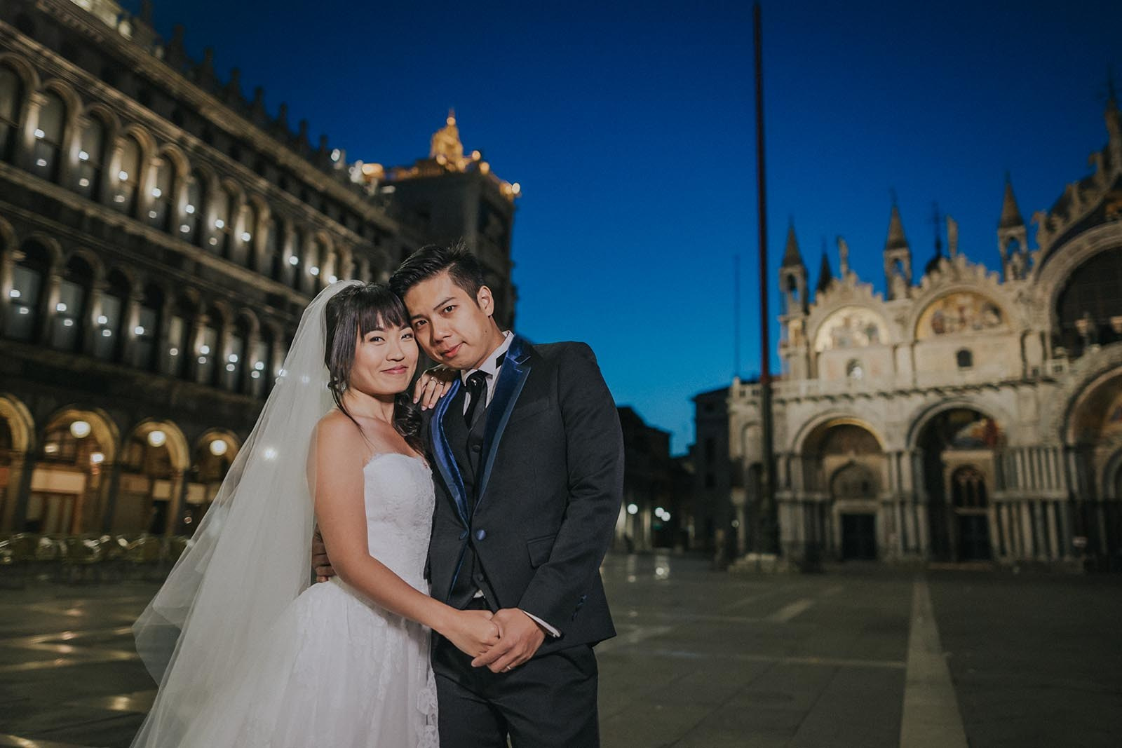 Newlyweds embrace in empty St. Mark's Square at twilight in Venice - Kurt Vinion Photography