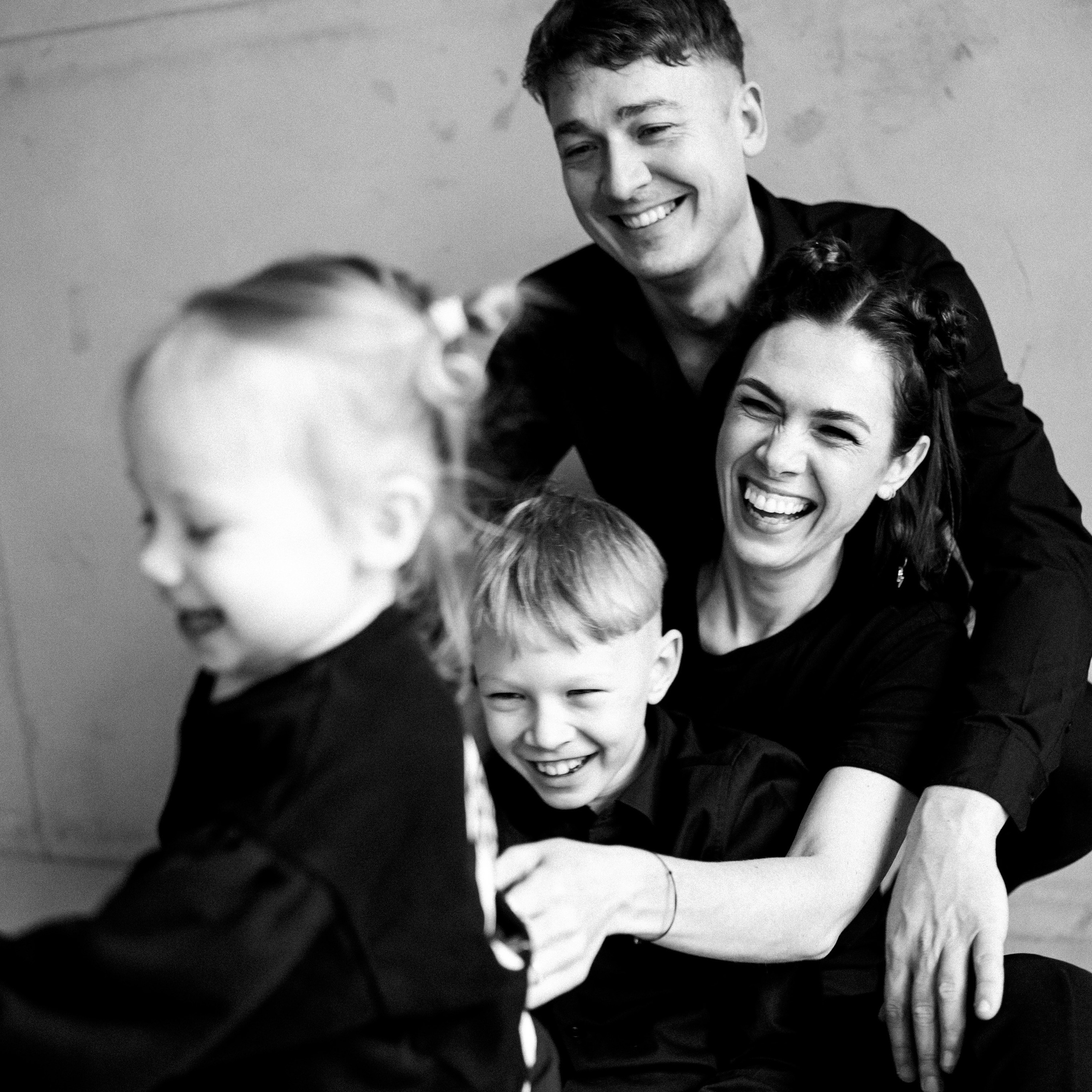 Šeimos fotosesija su tėvais ir vaikais, žaisminga ir šilta atmosfera.