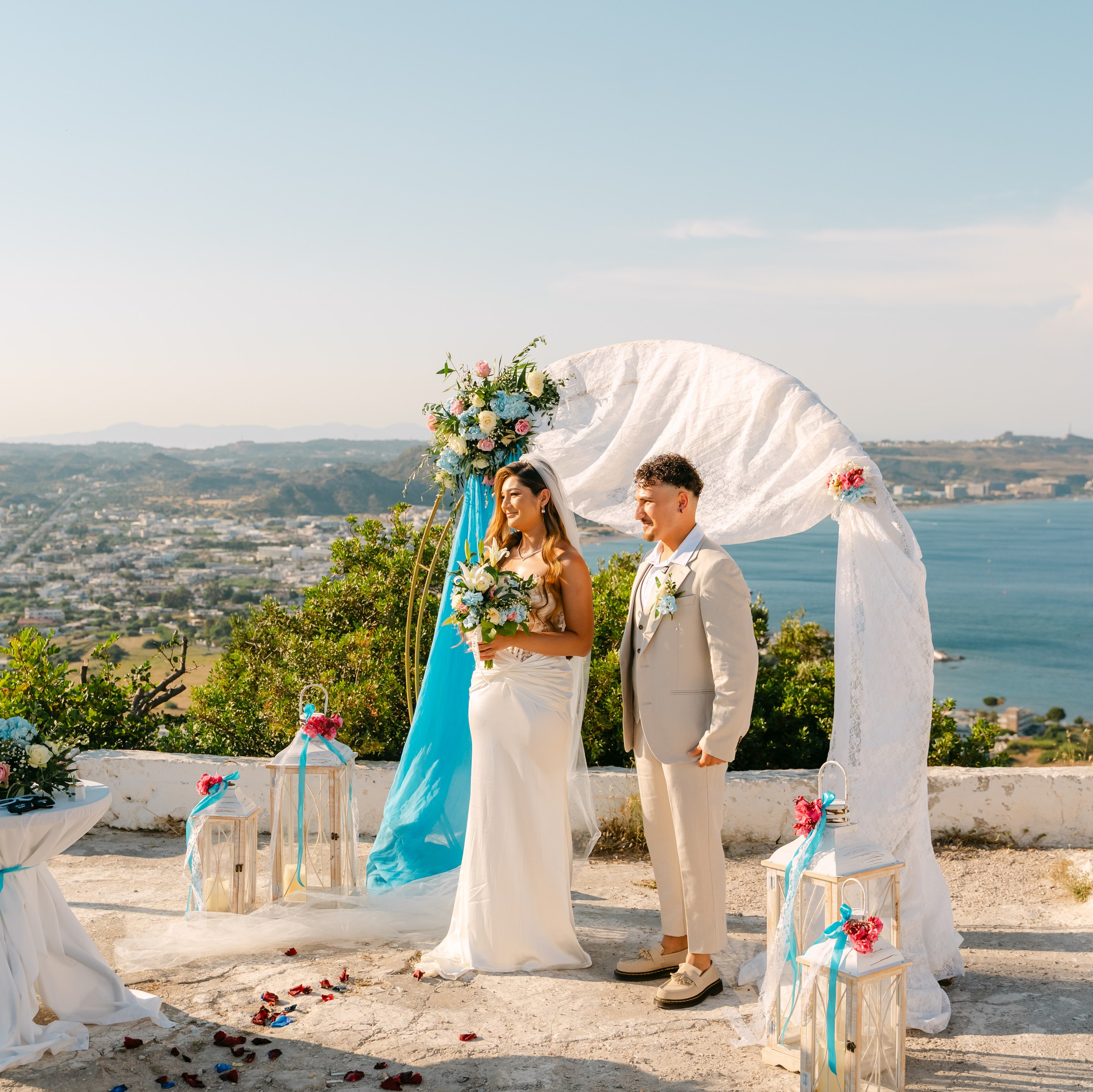 Brautpaar bei einer romantischen Strandhochzeit auf Rhodos unter einem liebevoll dekorierten Traubogen mit traumhaftem Meerblick. Diese Destination Wedding in Griechenland vereint mediterranes Flair, türkisblaues Wasser und unvergessliche Momente. Perfekt für Paare, die von Heiraten auf Rhodos, einer Strandhochzeit in Griechenland oder einem stilvollen Elopement am Meer träumen.