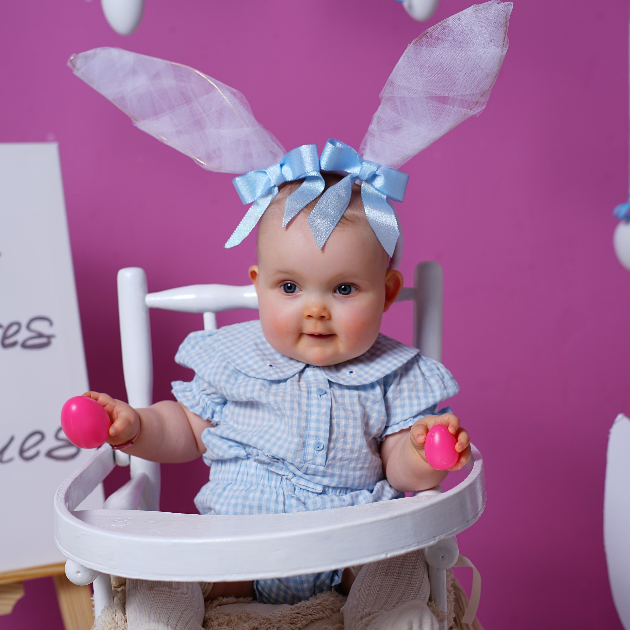 Séance photo bébé à Roanne – bébé souriant avec des oreilles de lapin sur fond rose.
