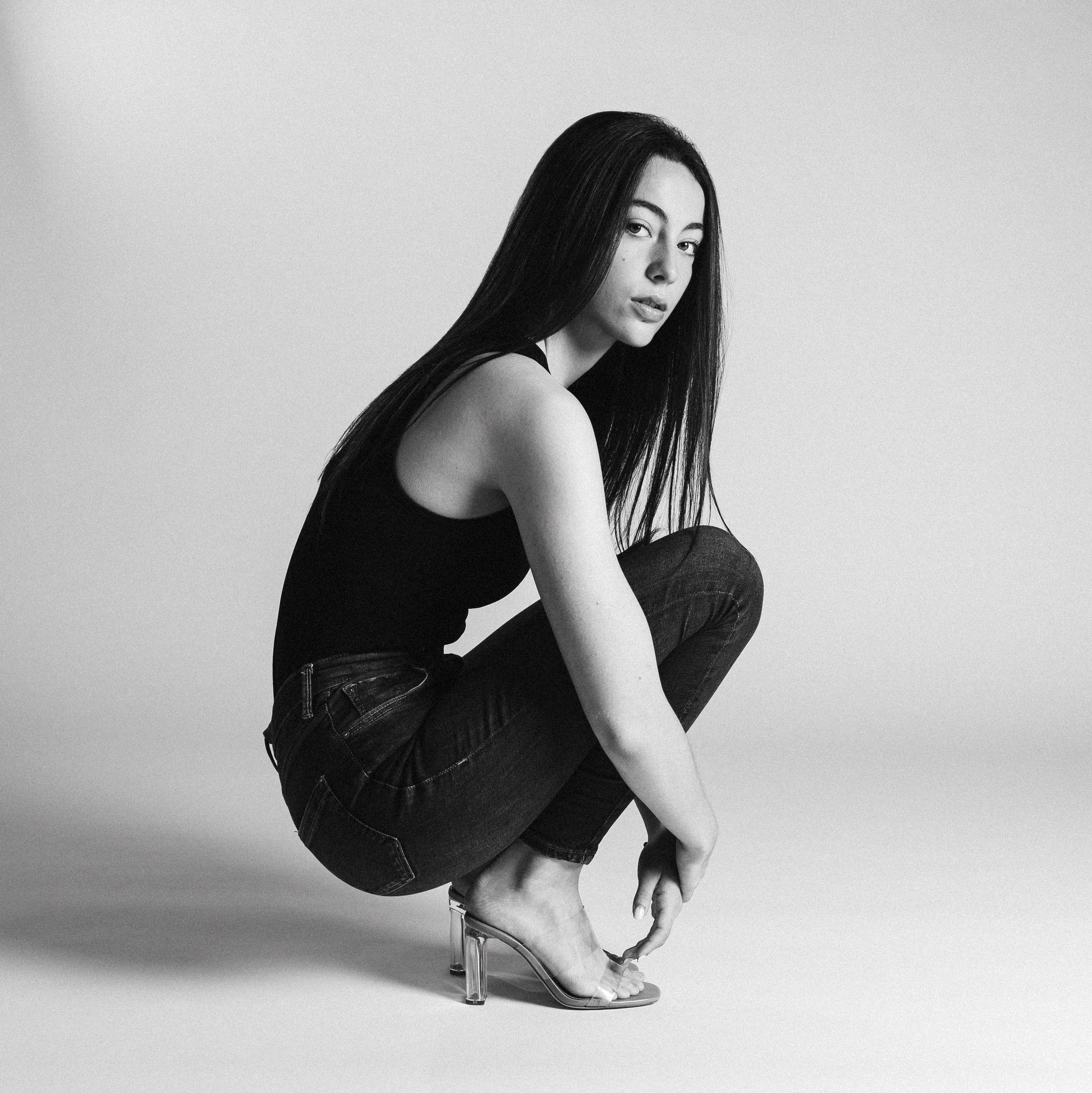 Chica joven posando en una sesión de fotos en estudio para su agencia de modelos, con una expresión confiada y elegante, capturando su potencial y presencia profesional