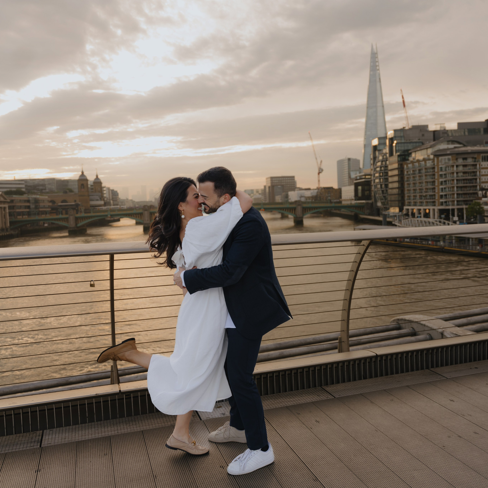 Couple kissing at sunset by the river Thames, London photoshoot