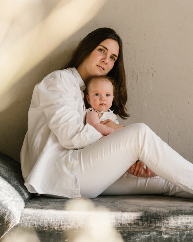 Mother is holding her small child and posing for photographer 