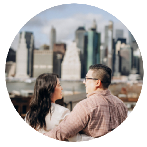 Engaged couple embracing under the Brooklyn Bridge skyline