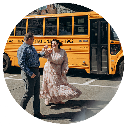 Romantic couple dancing in Dumbo, Brooklyn with Manhattan Bridge in the background — candid NYC engagement photo