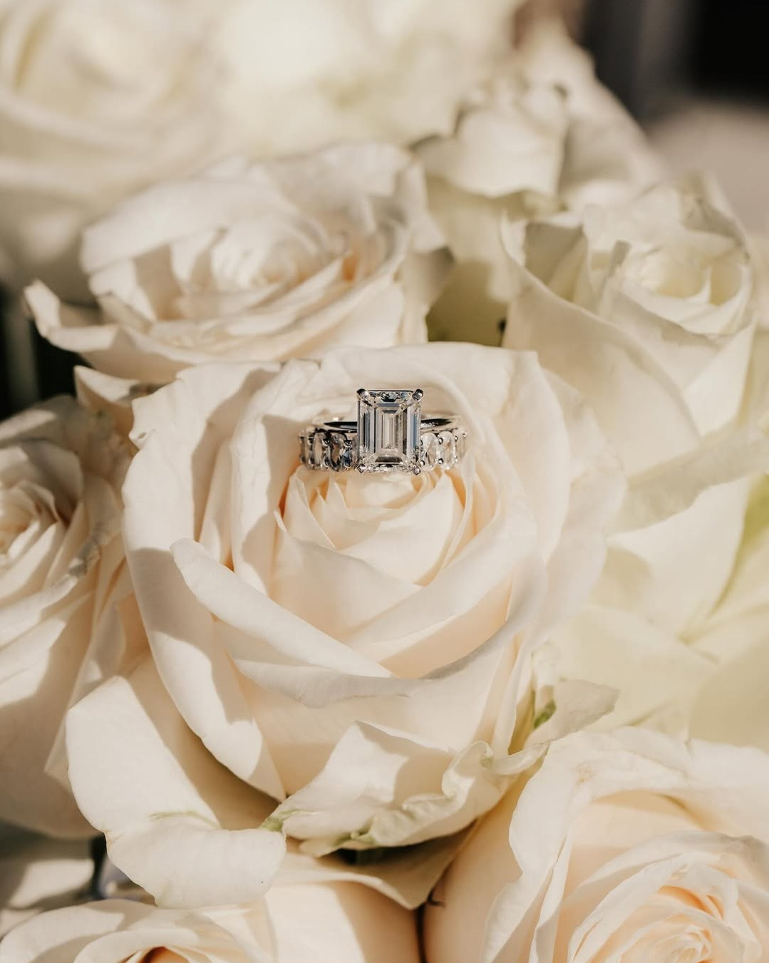 Wedding rings arranged on a white bridal bouquet