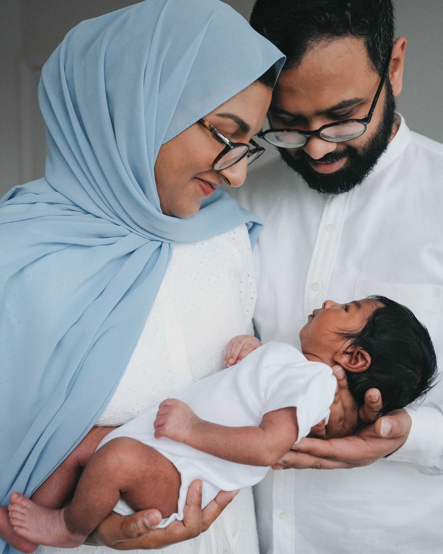 At-home newborn photo session in Solihull with Irina Zoteeva. Mum is holding baby's feet.