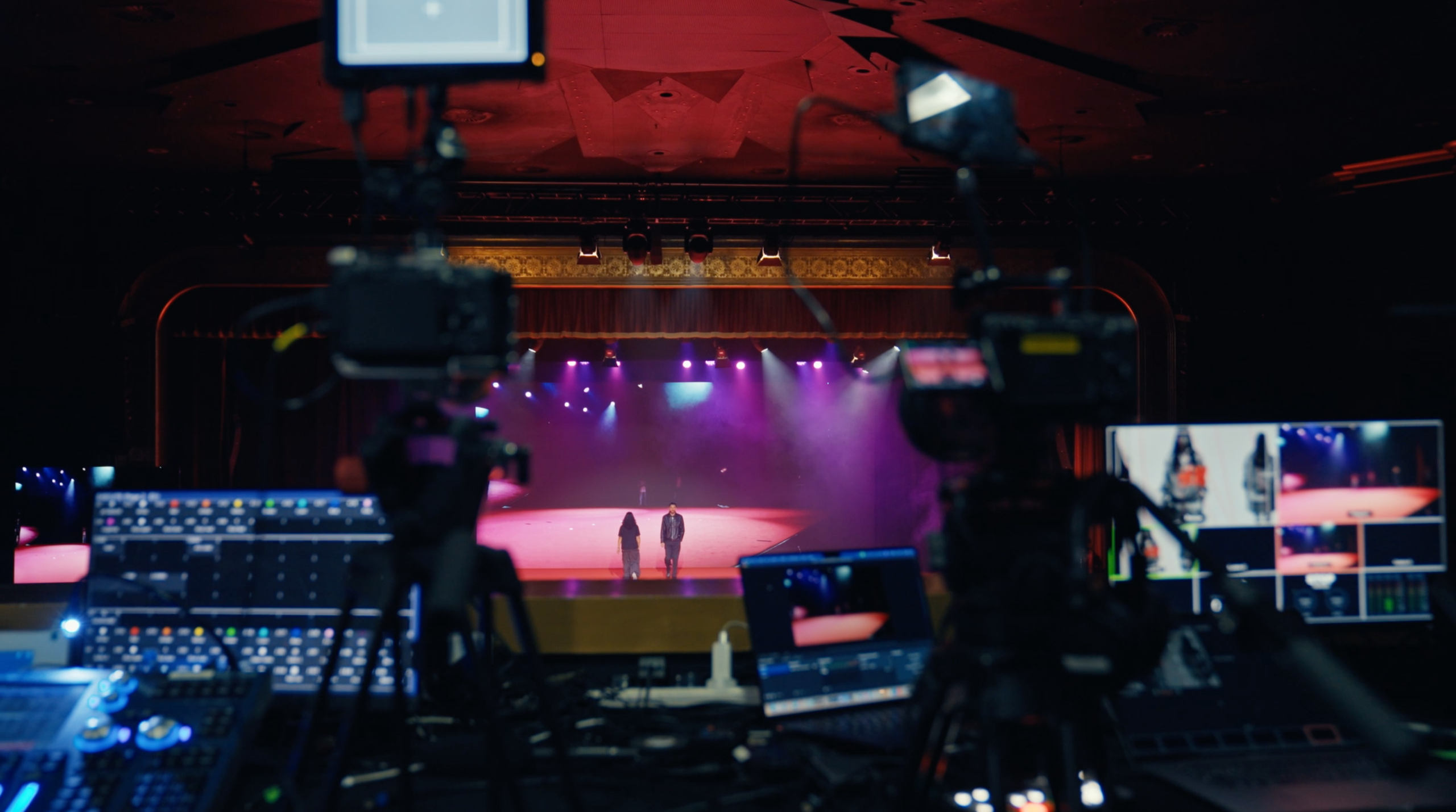 Multi-camera live streaming control station overlooking a corporate event stage