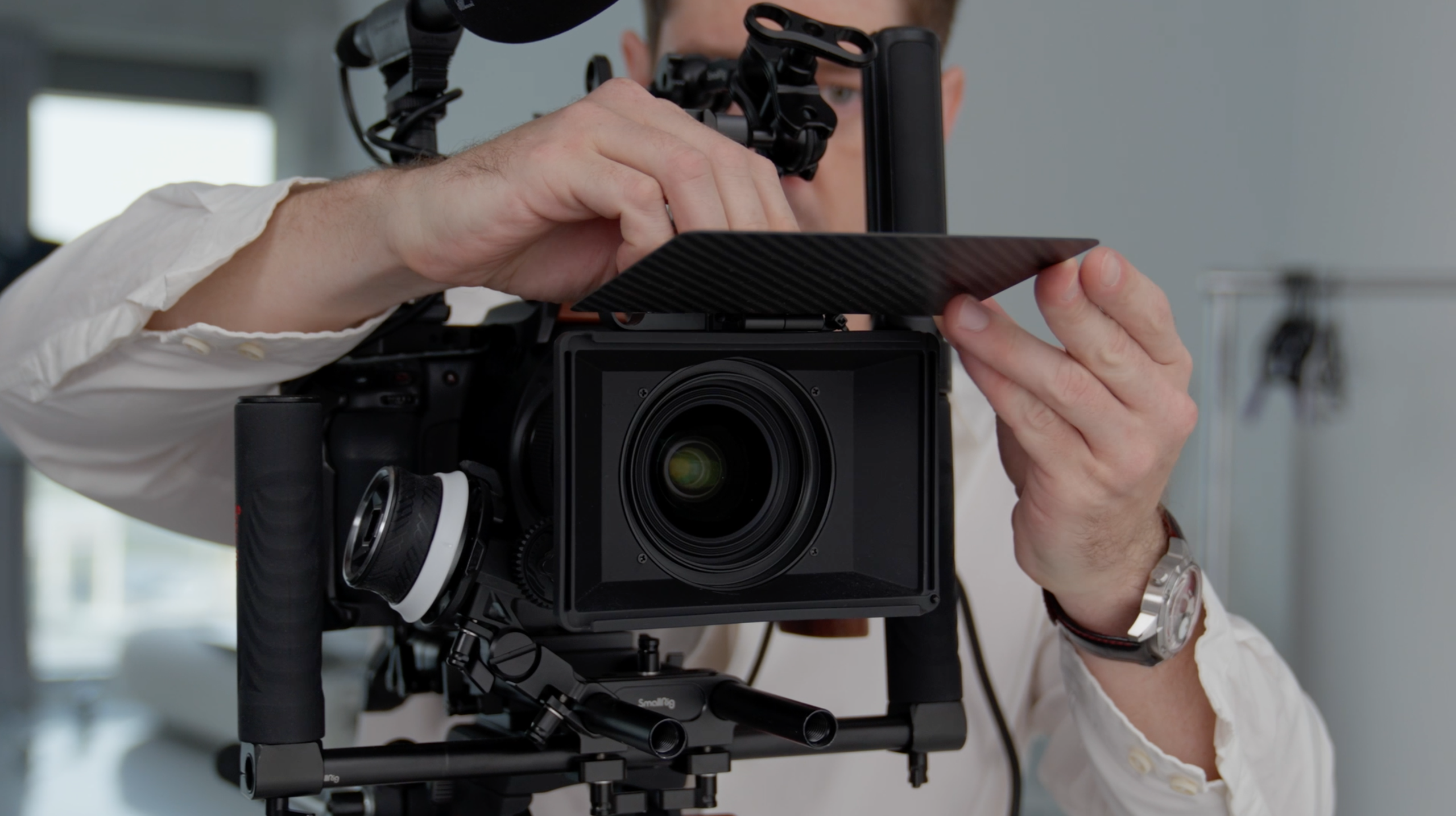 Camera operator adjusting a professional cinema camera before a live video production