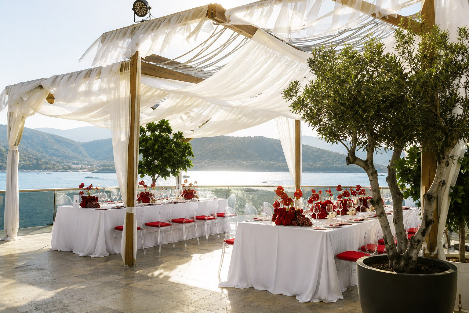 Bodrum wedding design concept with white draping, red flowers and panoramic Aegean Sea views