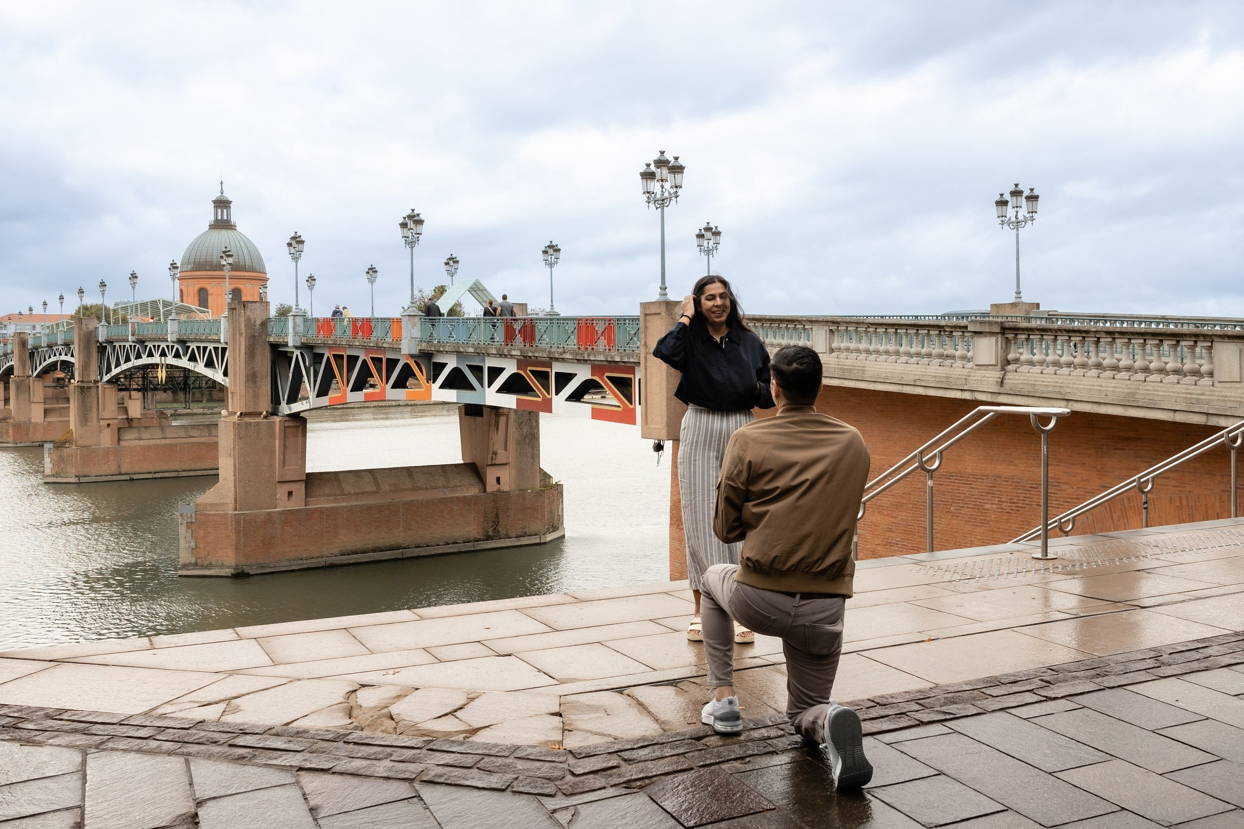 Surprise proposal at Pont Neuf in Toulouse captured discreetly by a proposal photographer