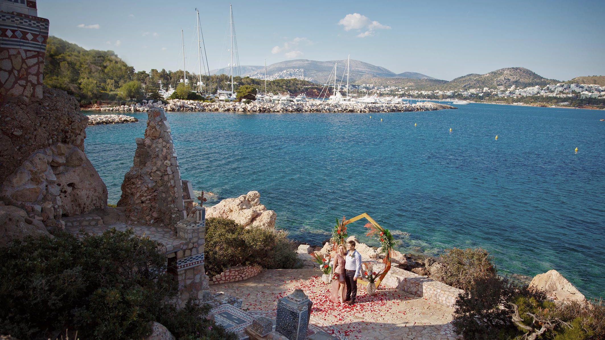 Молодожены на фоне моря и арки на свадебной церемонии на Крите. Фотограф, свадьба в Греции.