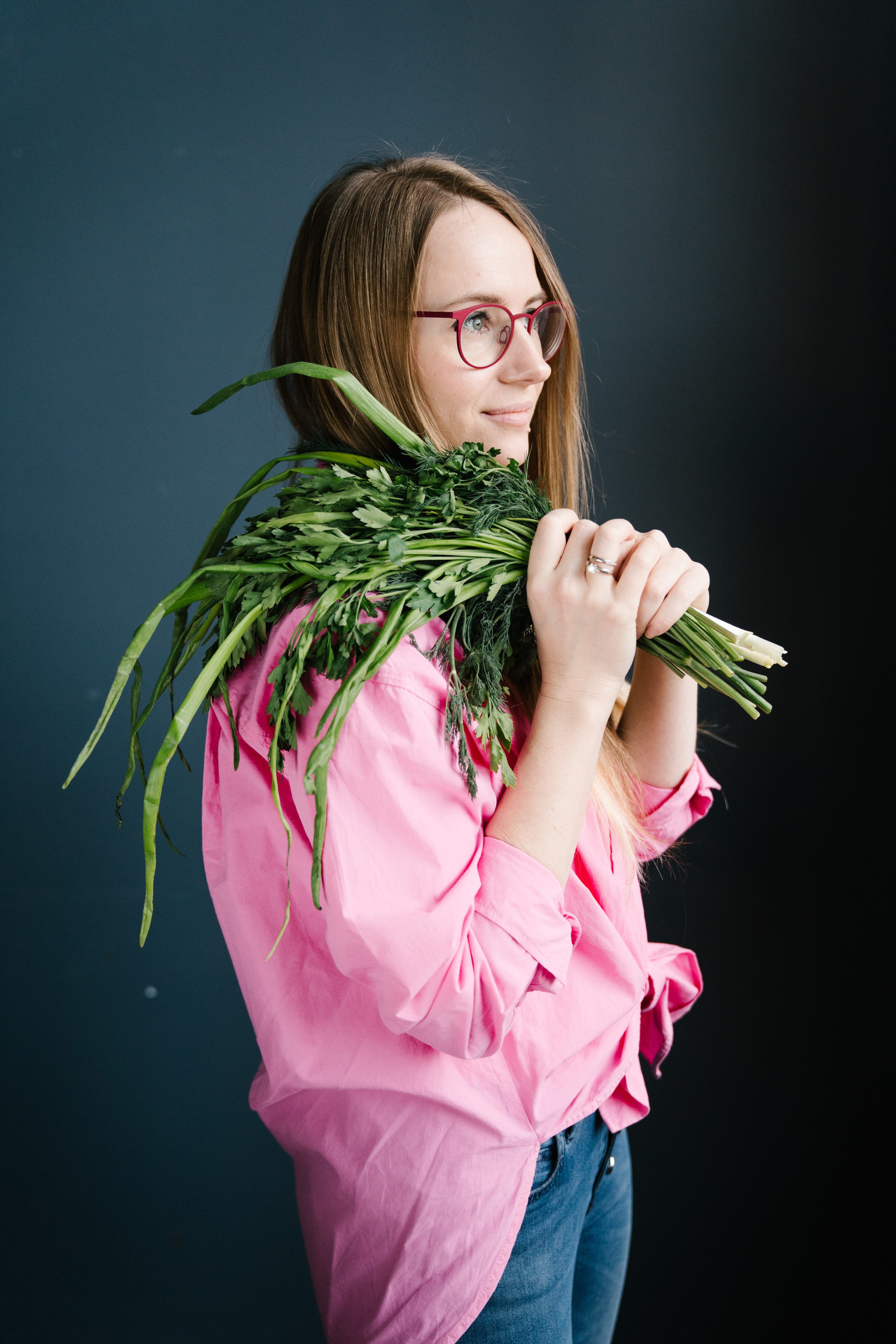Health specialist holding greens in a pink shirt