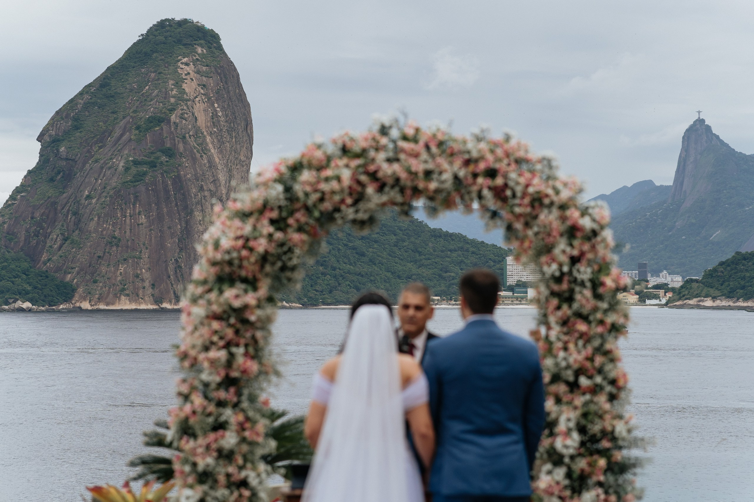 Casal em cerimônia de casamento ao ar livre com vista para o Pão de Açúcar e Cristo Redentor