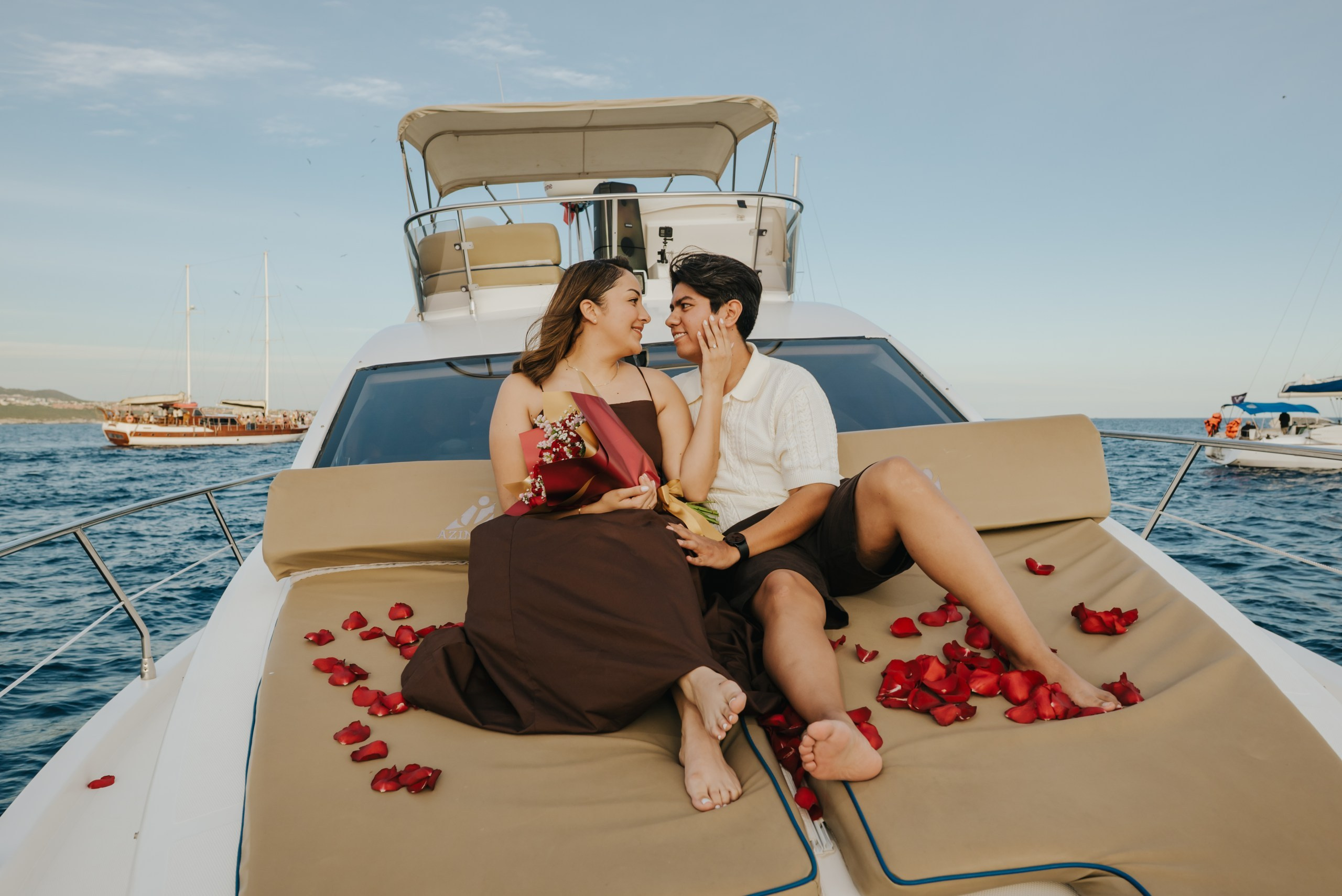 Couple surrounded by roses on a yacht proposal in Los Cabos