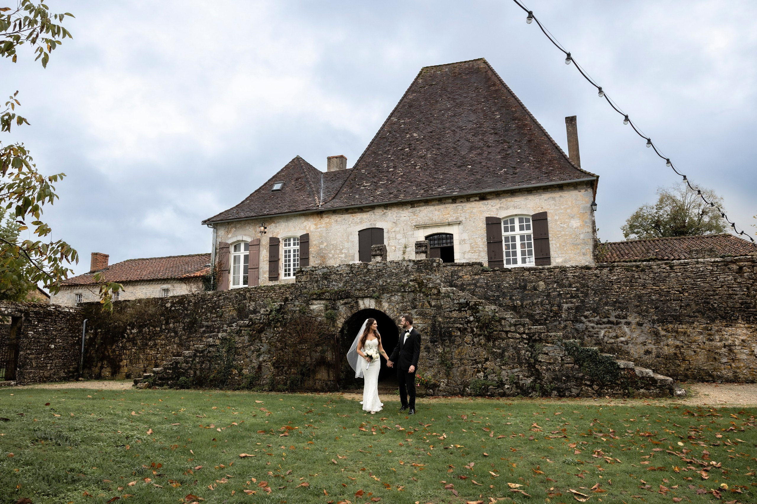 Mariage dans un château en Dordogne devant un domaine en pierre historique.