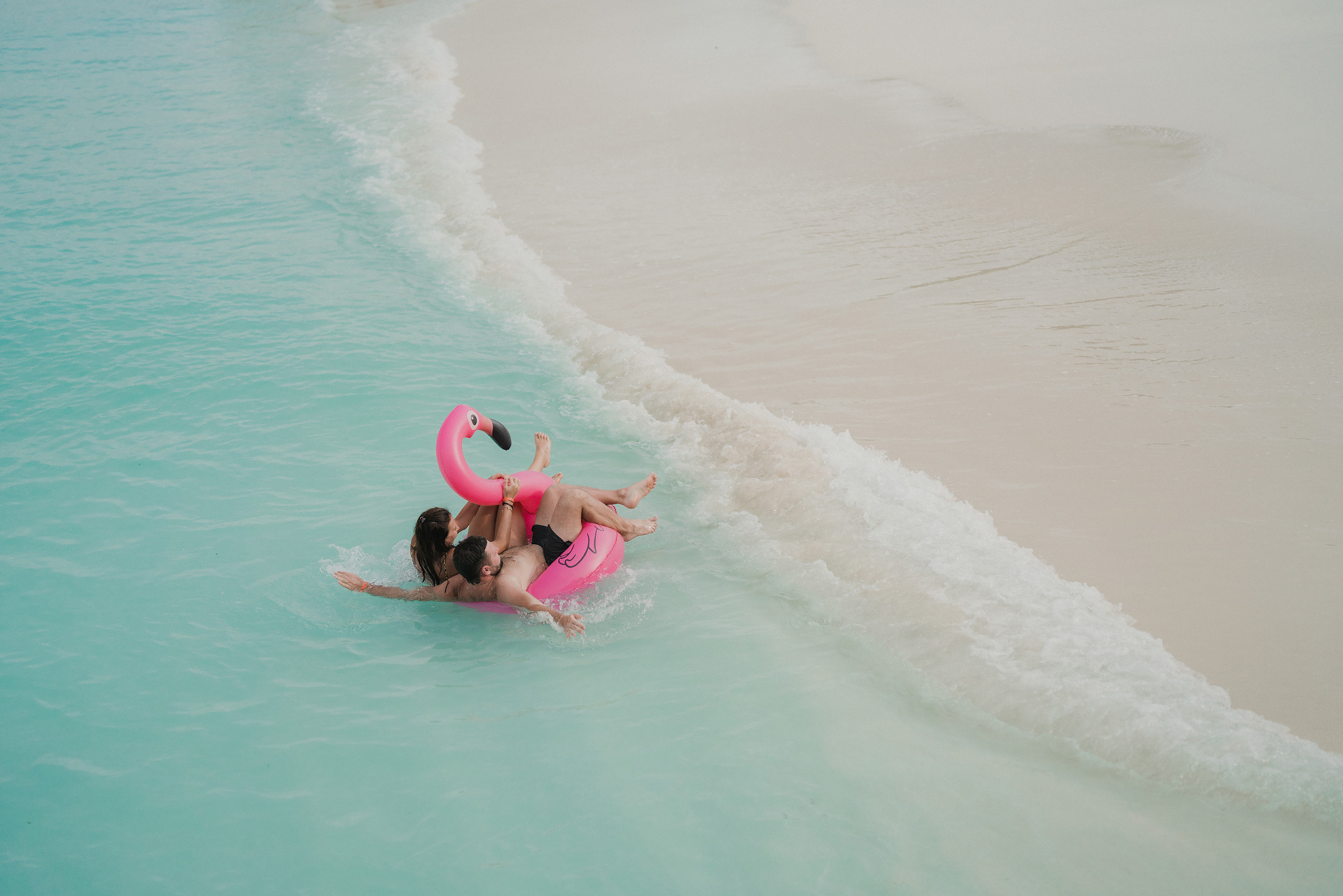 Couple on a rubber flamingo in the Indian ocean
