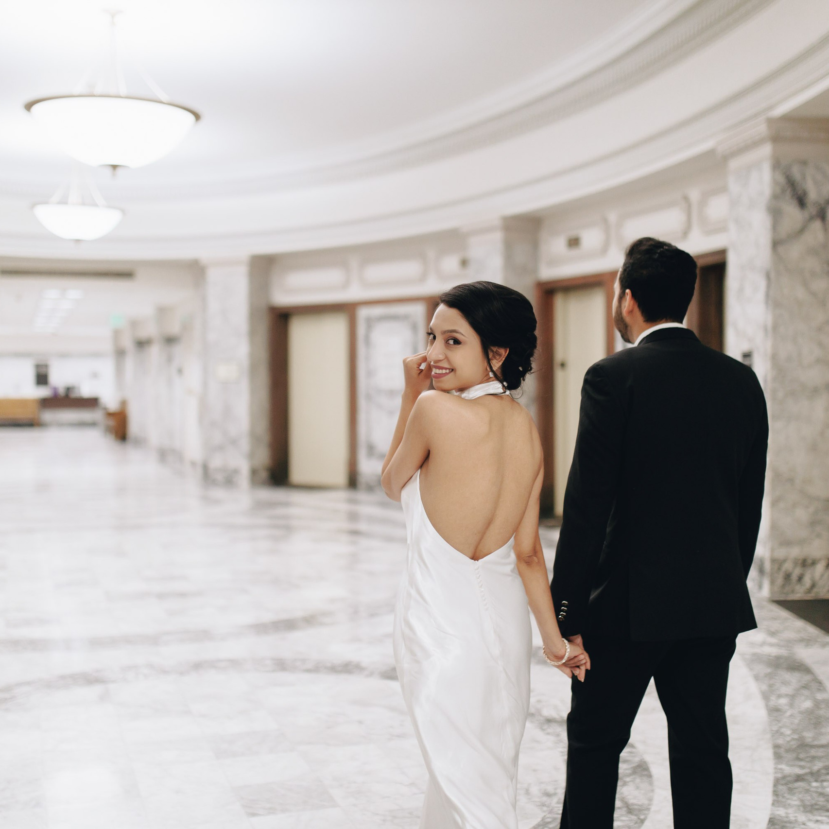 Bride and groom walking in elegant hallway