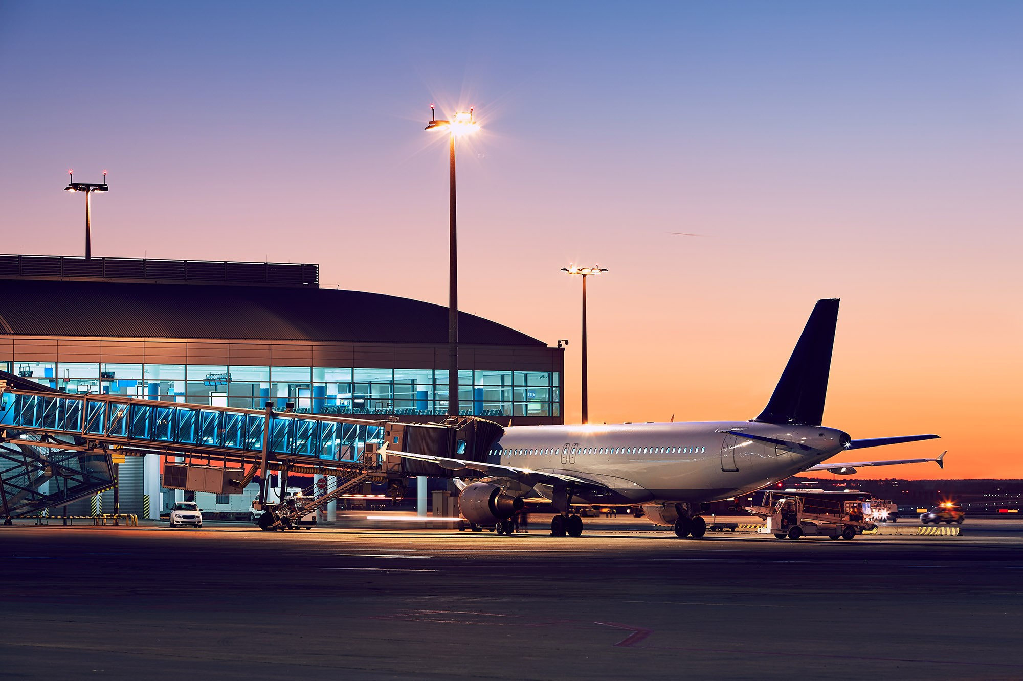 Athens International Airport at sunset with airplane preparing for departure, symbolizing arrival to Greece.