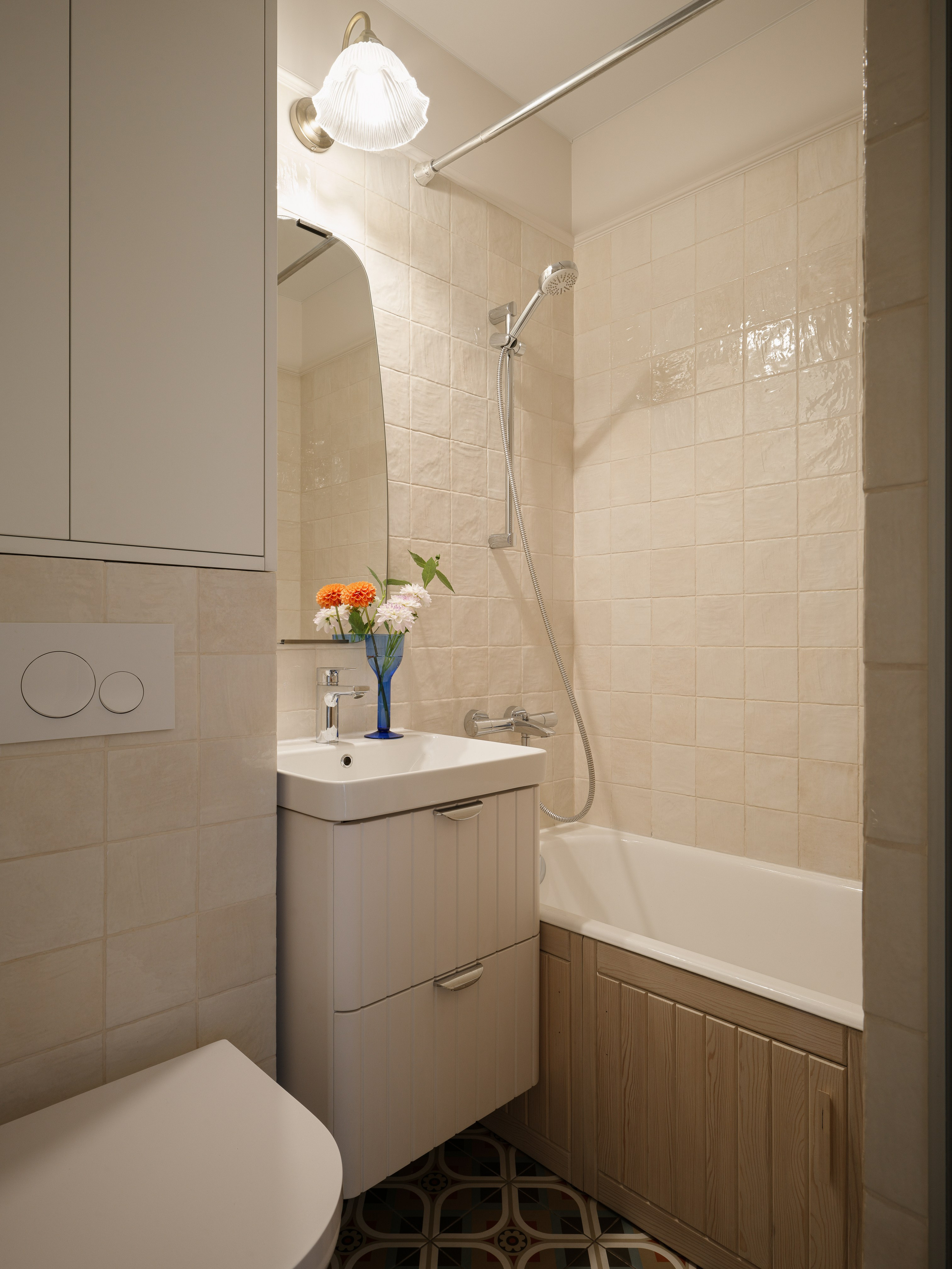 Деревянный экран под ванной как теплый акцент в минималистичном санузле.