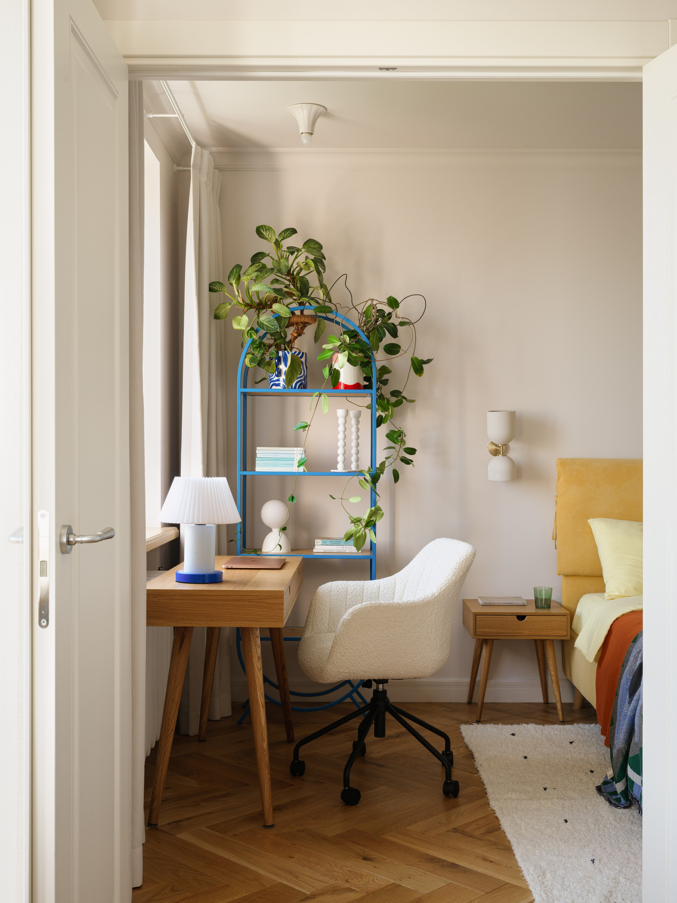 Синий металлический стеллаж с книгами и декором в спальне в стиле ретро.