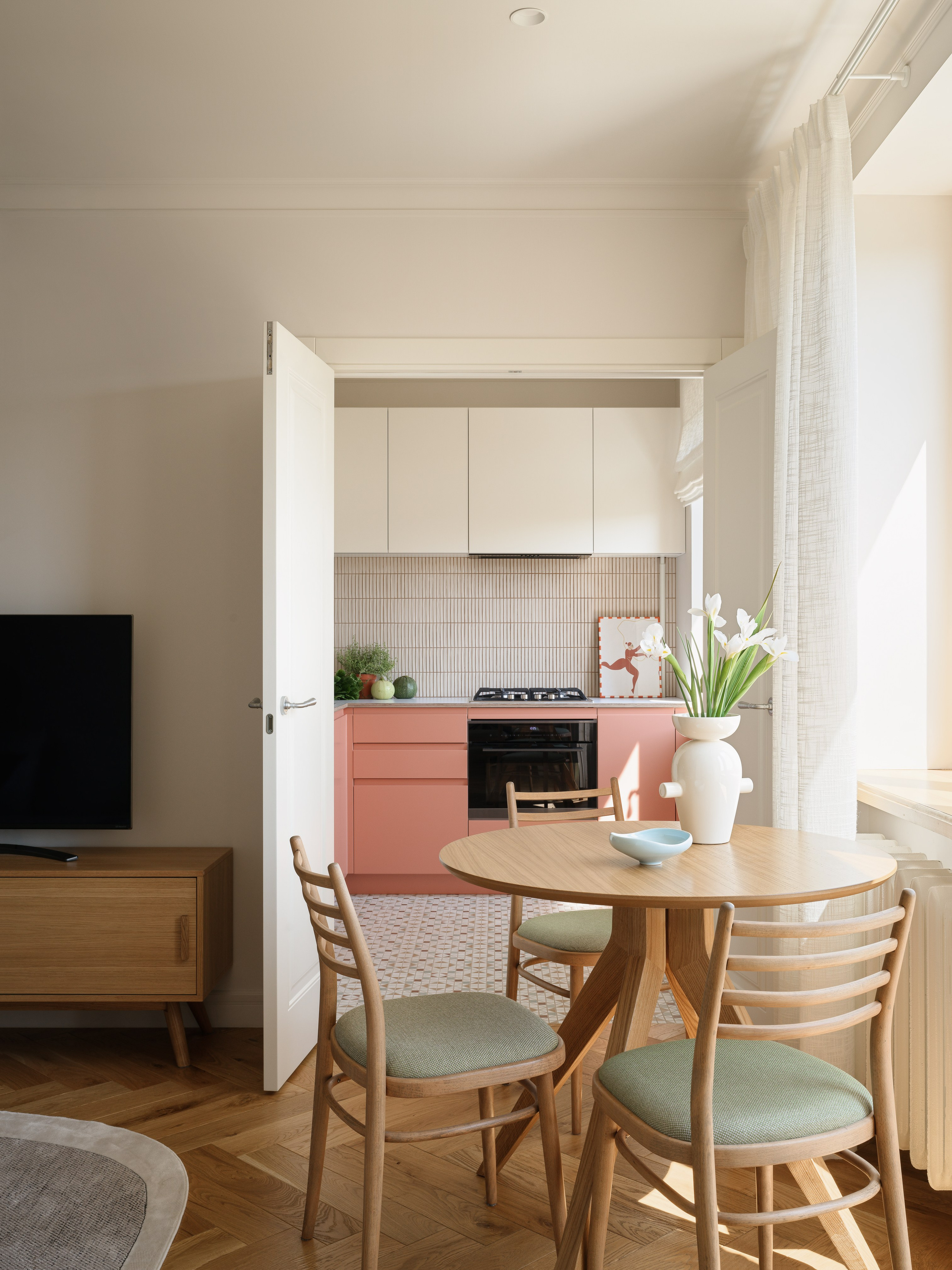 Вид из гостиной с паркетом елочкой на яркую кухню с мозаичным полом.