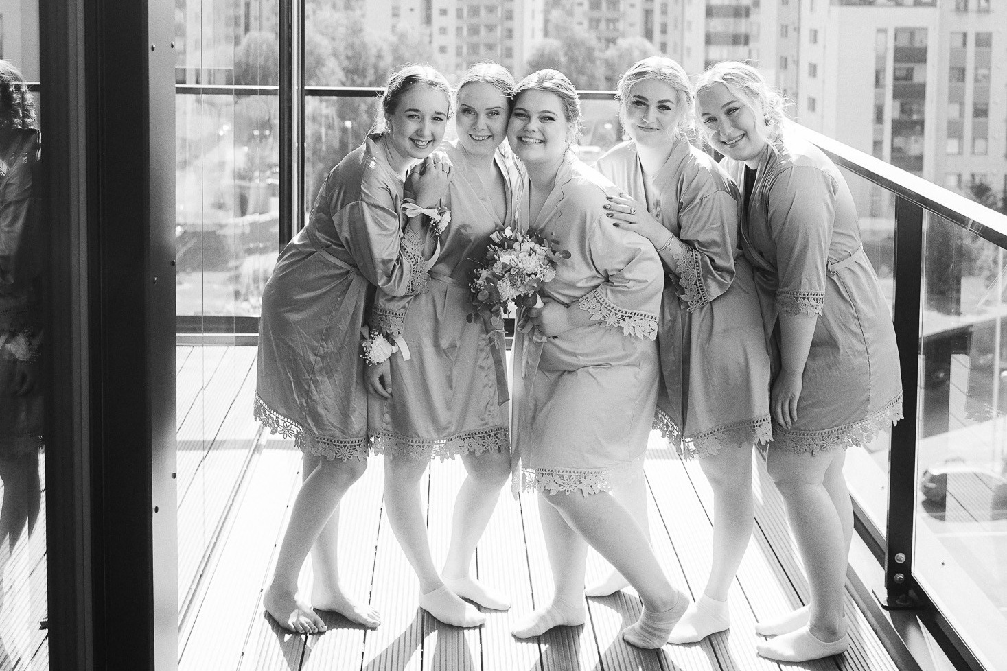 Bride and bridesmaids in robes on a terrace, black and white wedding photo by a Helsinki wedding photographer