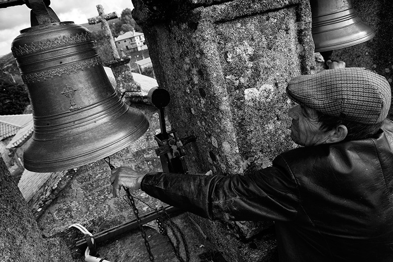 Man rings the bell to alert the people of the village to the beginning of mass, Montalegre municipality, Vila Real district, Trás-os-Montes region, Portugal. 2016