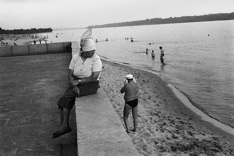 Женщина сидящая на парапете набережной на фоне пляжа. Правый берег Днепра, Запорожье, УССР. 1988