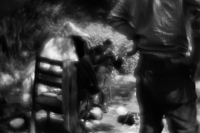 Борис сидит возле палатки Володи "Ботаника" и обсуждает с ним, что делать с найденными на помойке "золотом и бриллиантами": серебряной цепочкой и золотой цепочкой с кулоном, украшенными бриллиантами, район Тропарёво-Никулино, Москва, Россия. 31 мая 2015