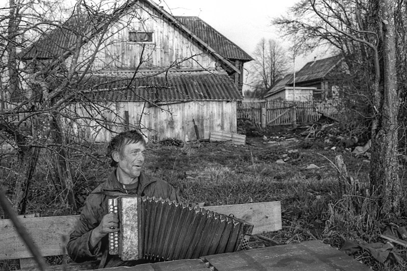 Grisha, a villager, stands next to his house in the village of Ivtsino on the River Volga, Yaroslavl region, Russia. April 2007 © Oleg Klimov